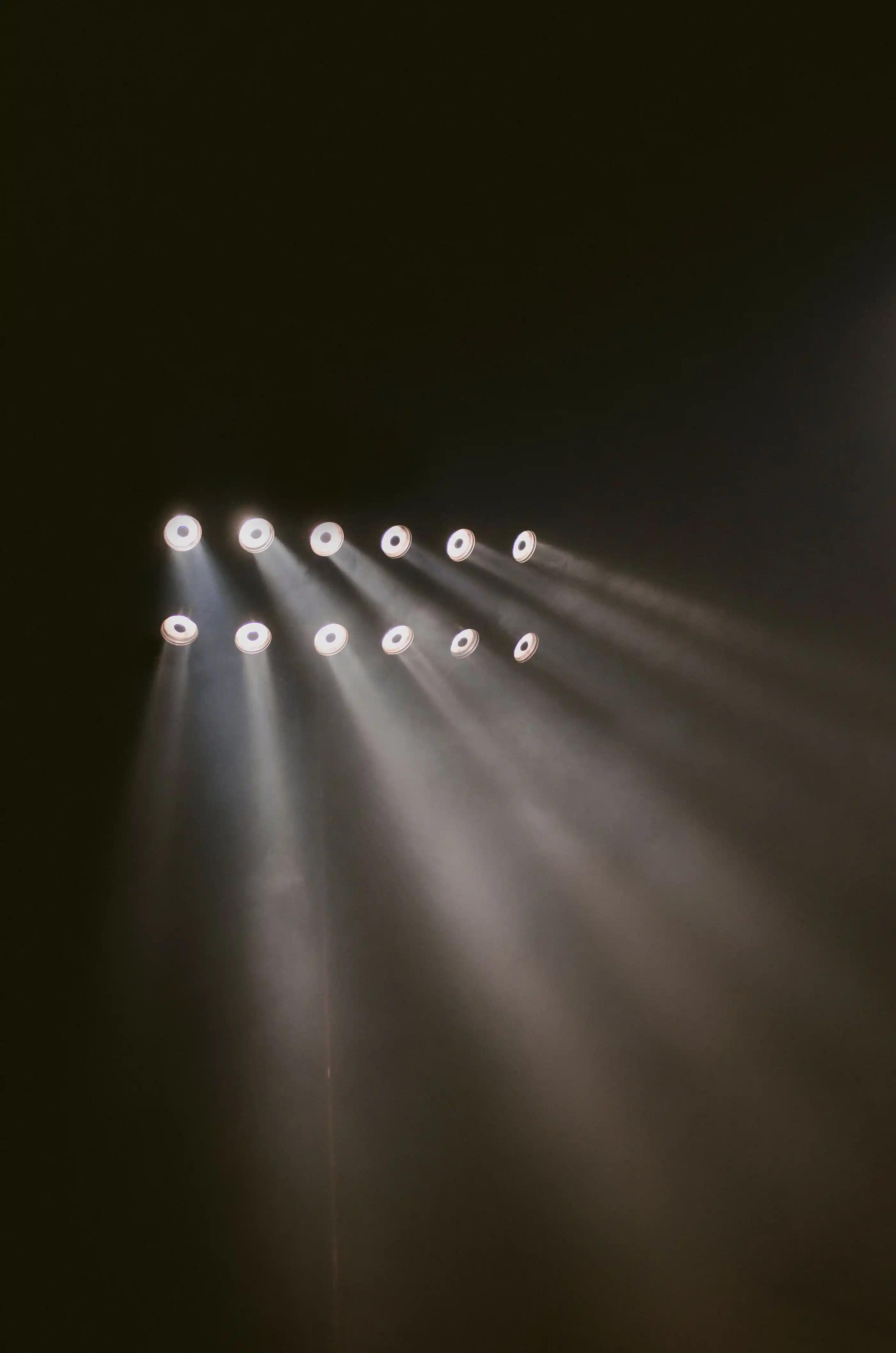 Beams of stage light cutting through haze in a dark room