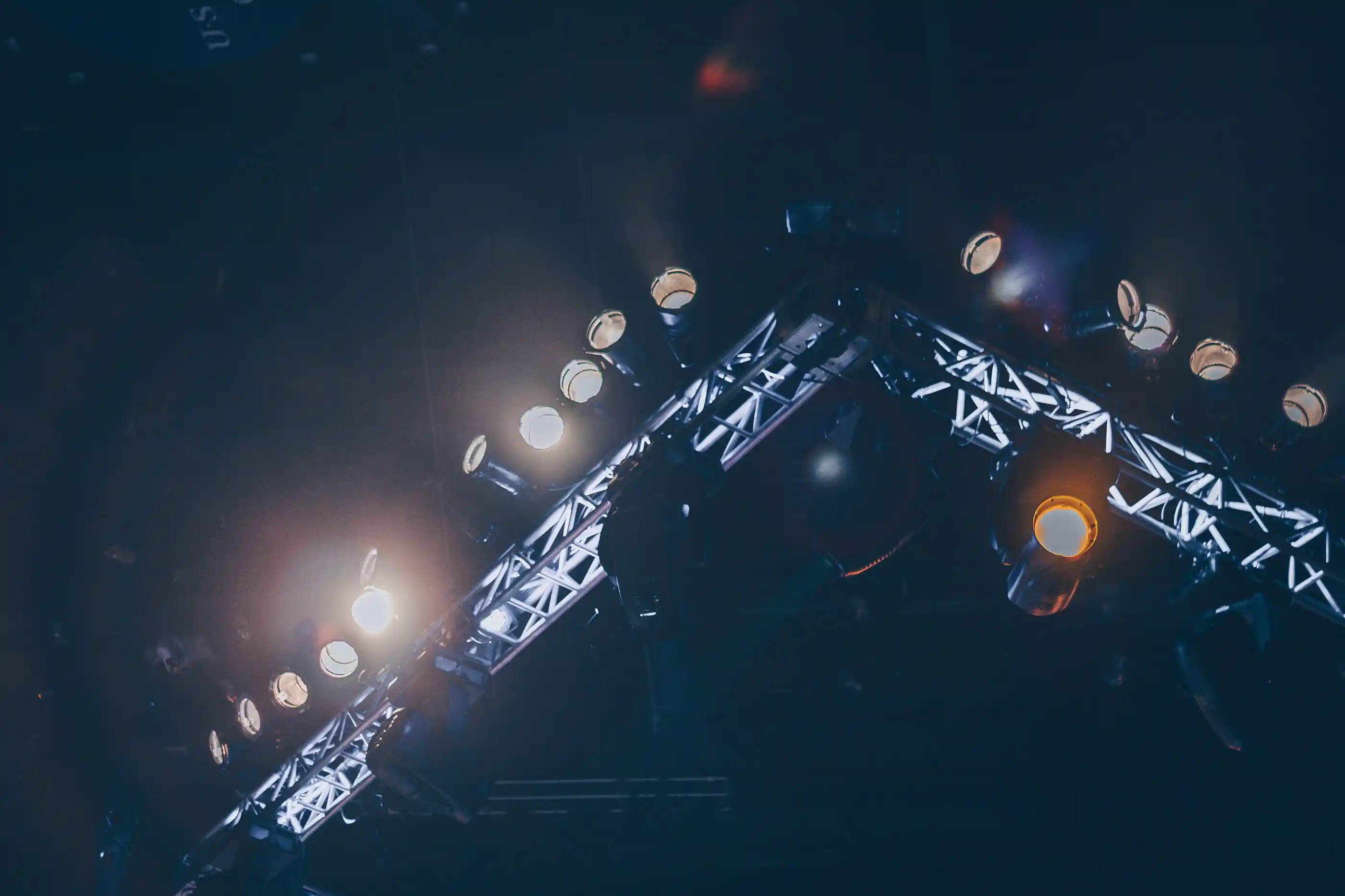 Stage lights washing an arena in white and blue before a show