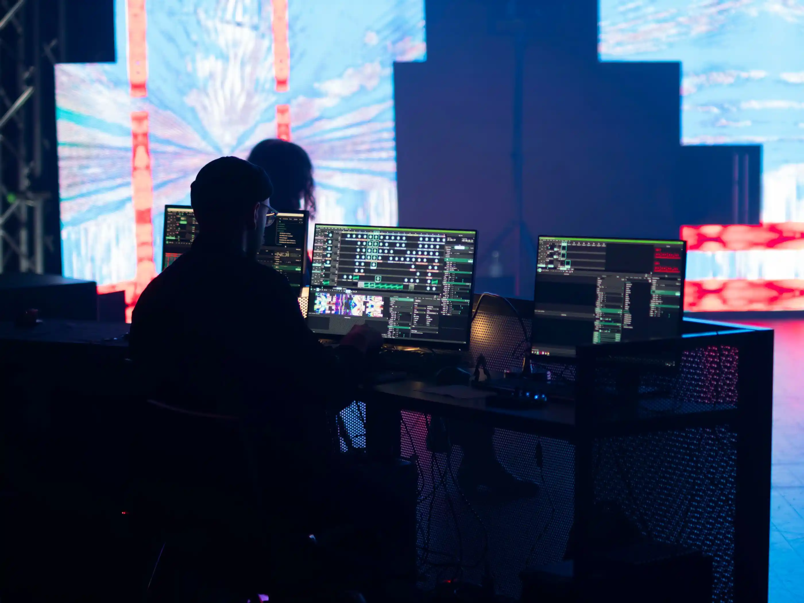 A technician watching multiple monitor feeds from a production position