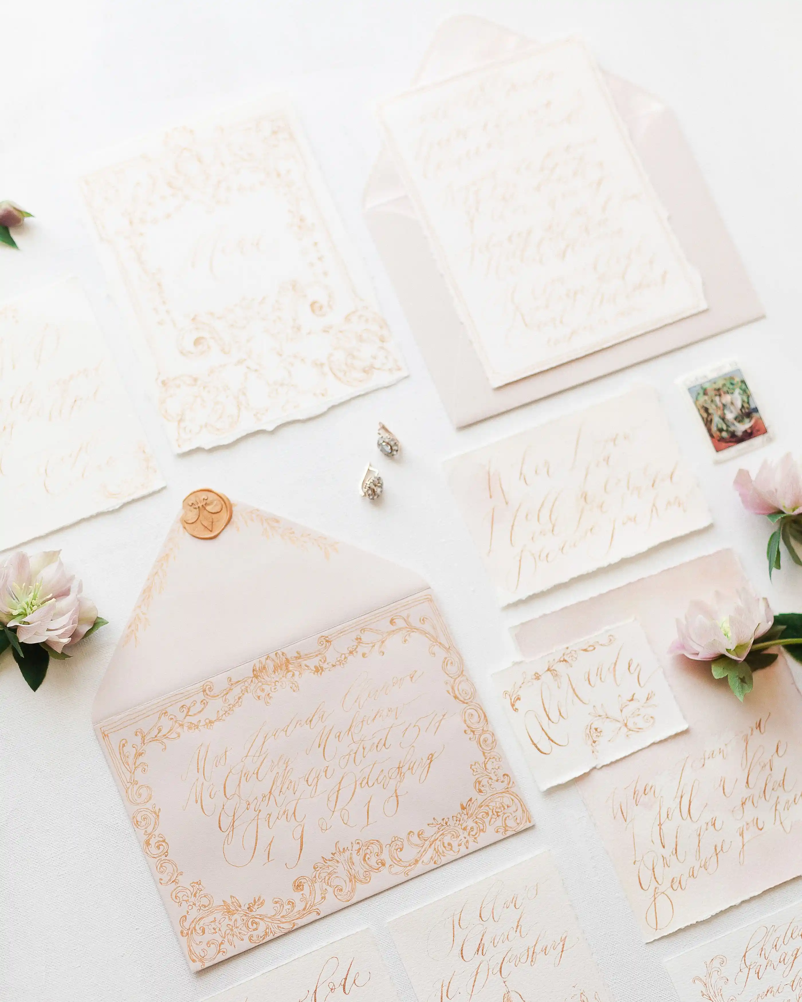 An invitation suite laid out flat with envelopes and floral detail