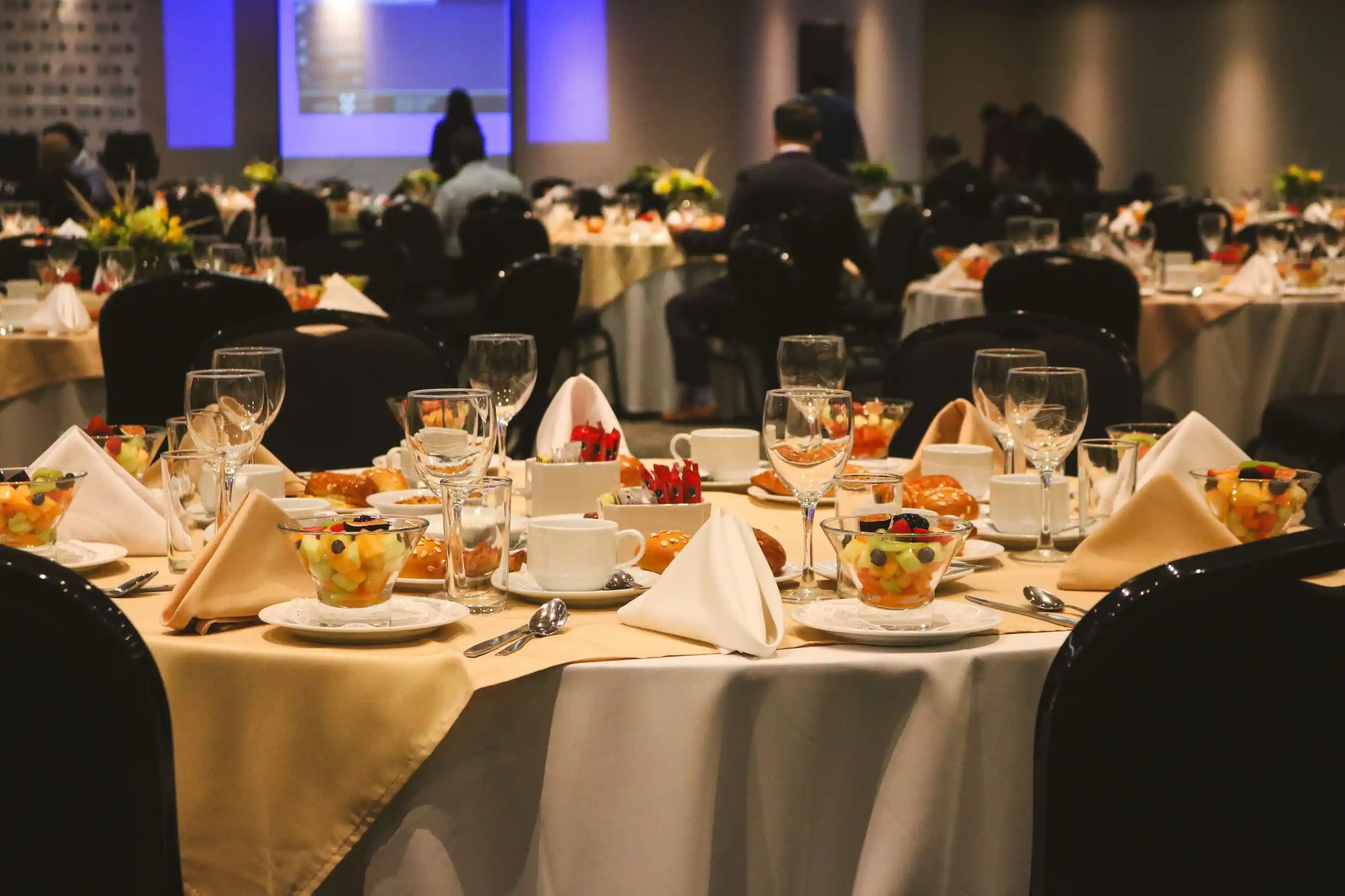 A banquet table laid for a large party, gold chargers at each place