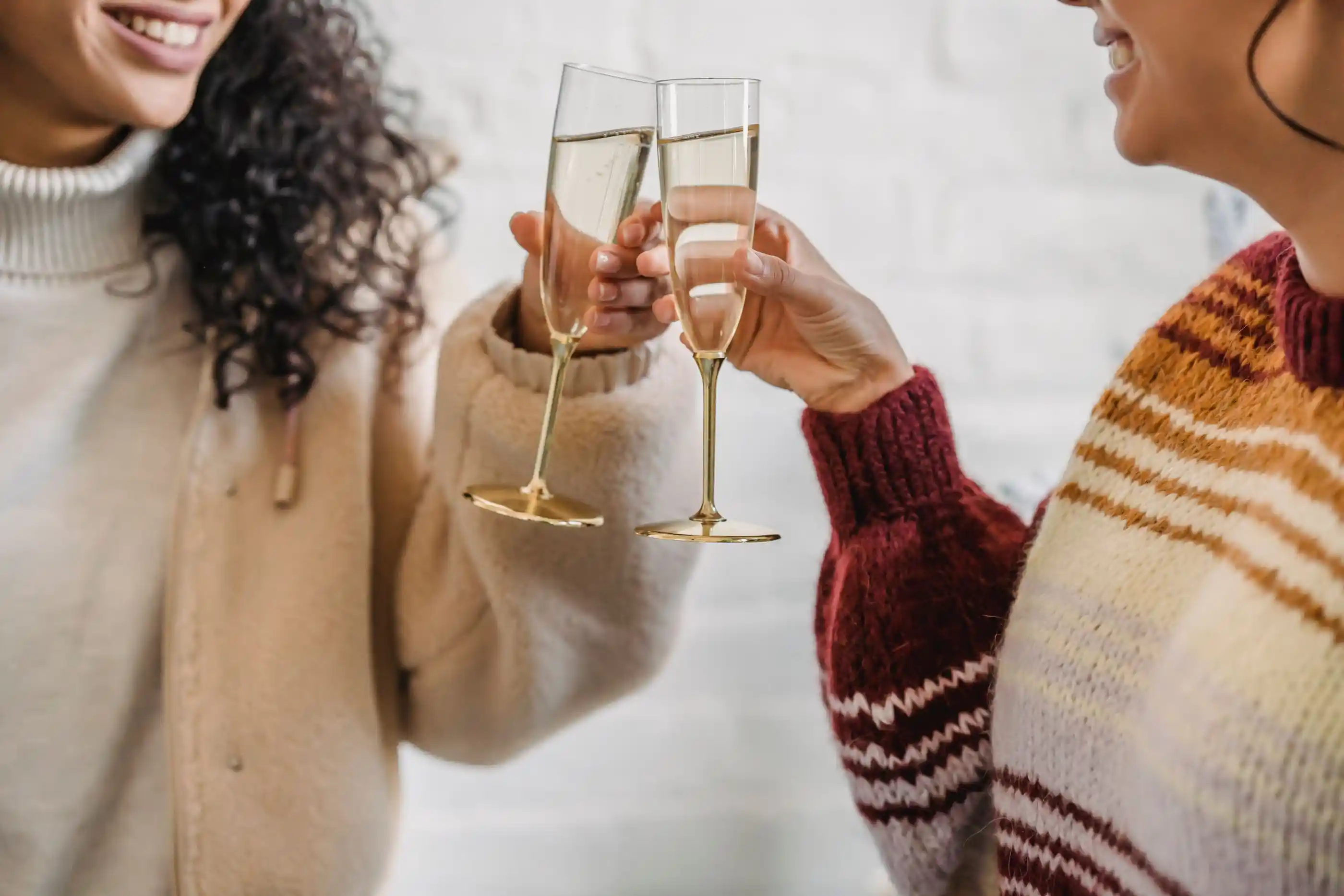 Two guests laughing as they raise champagne flutes