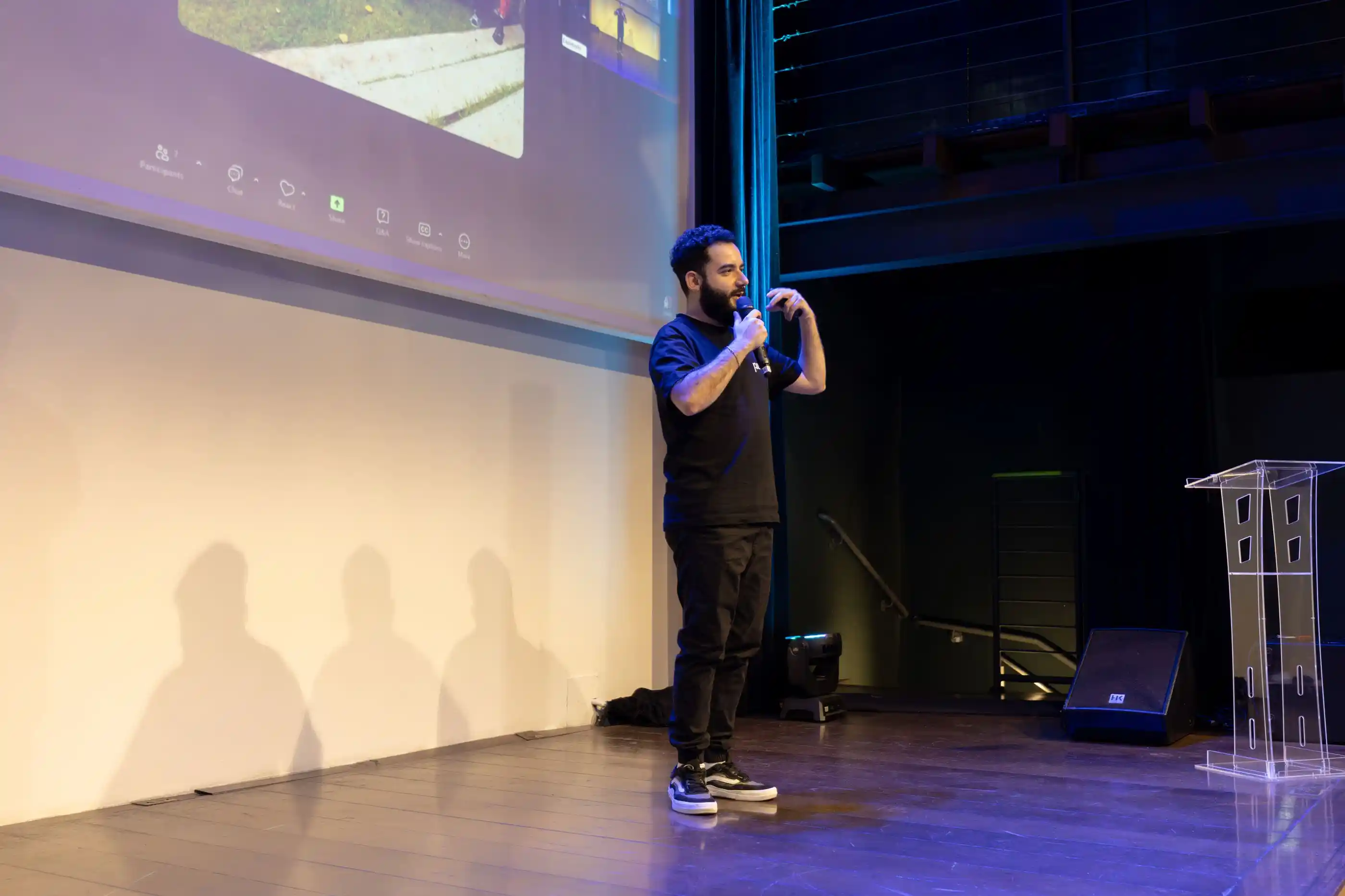 A speaker moving across a stage during a corporate keynote