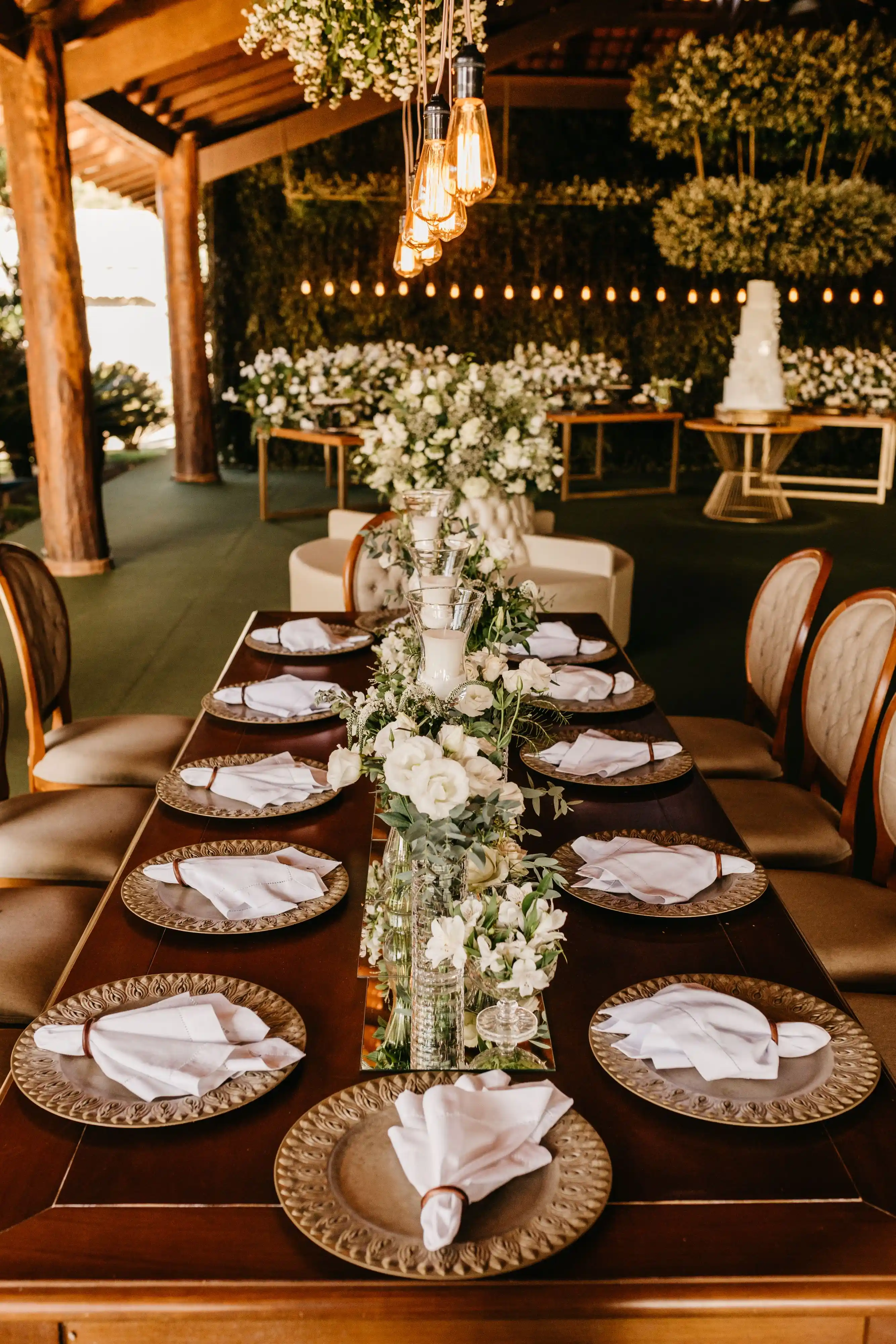 A wedding table dressed with greenery, candles and low blooms