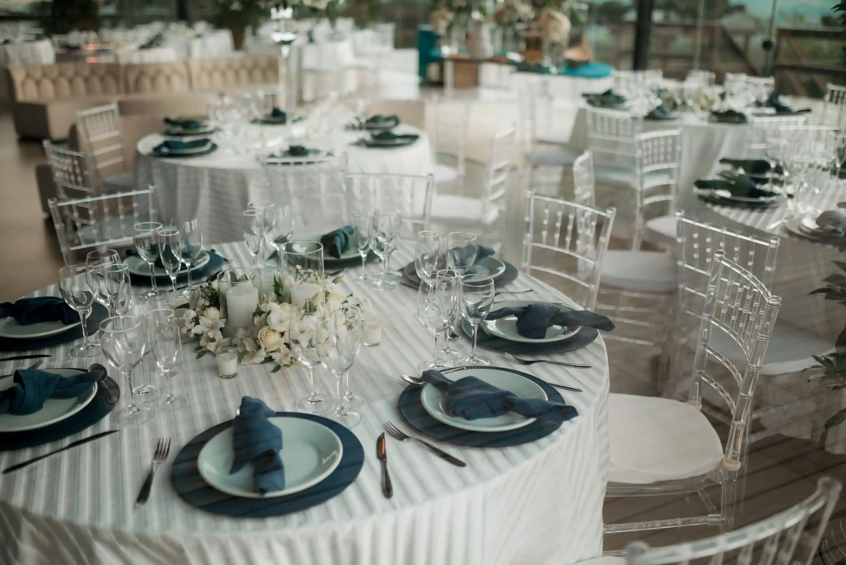 Round tables dressed in white and navy for an indoor wedding