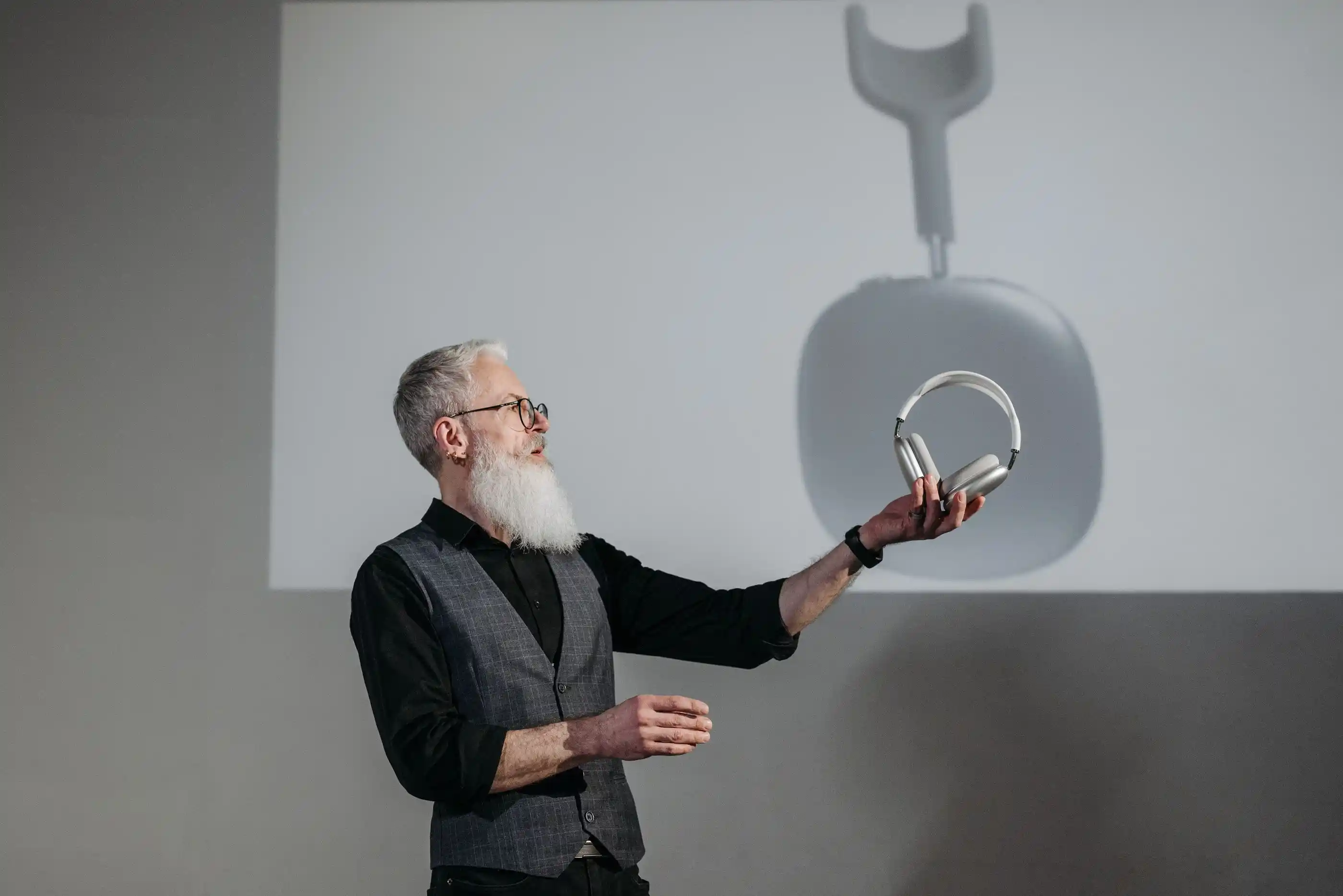 A presenter holding a product up to an audience in a bright room