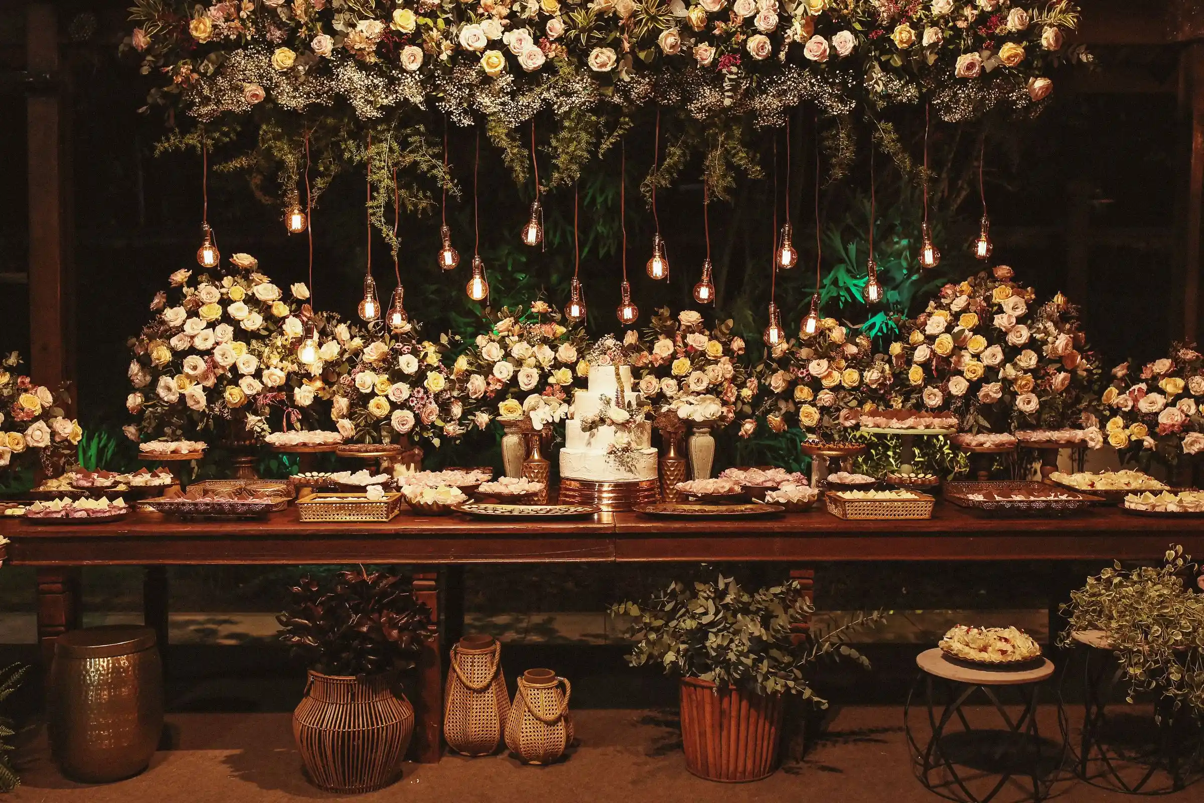 A reception table set with flowers and warm lighting overhead
