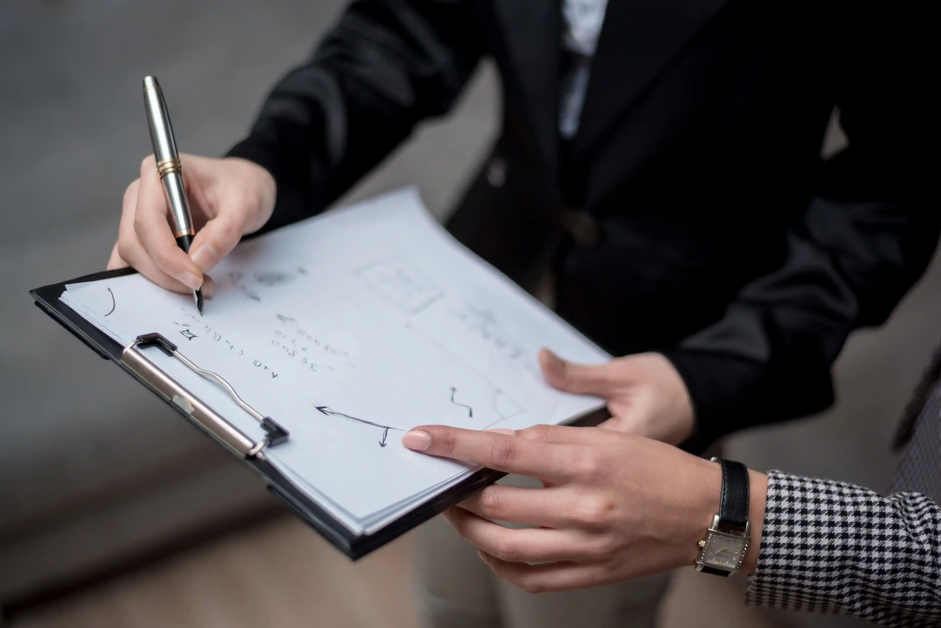 Hands annotating a printed run sheet during a planning meeting