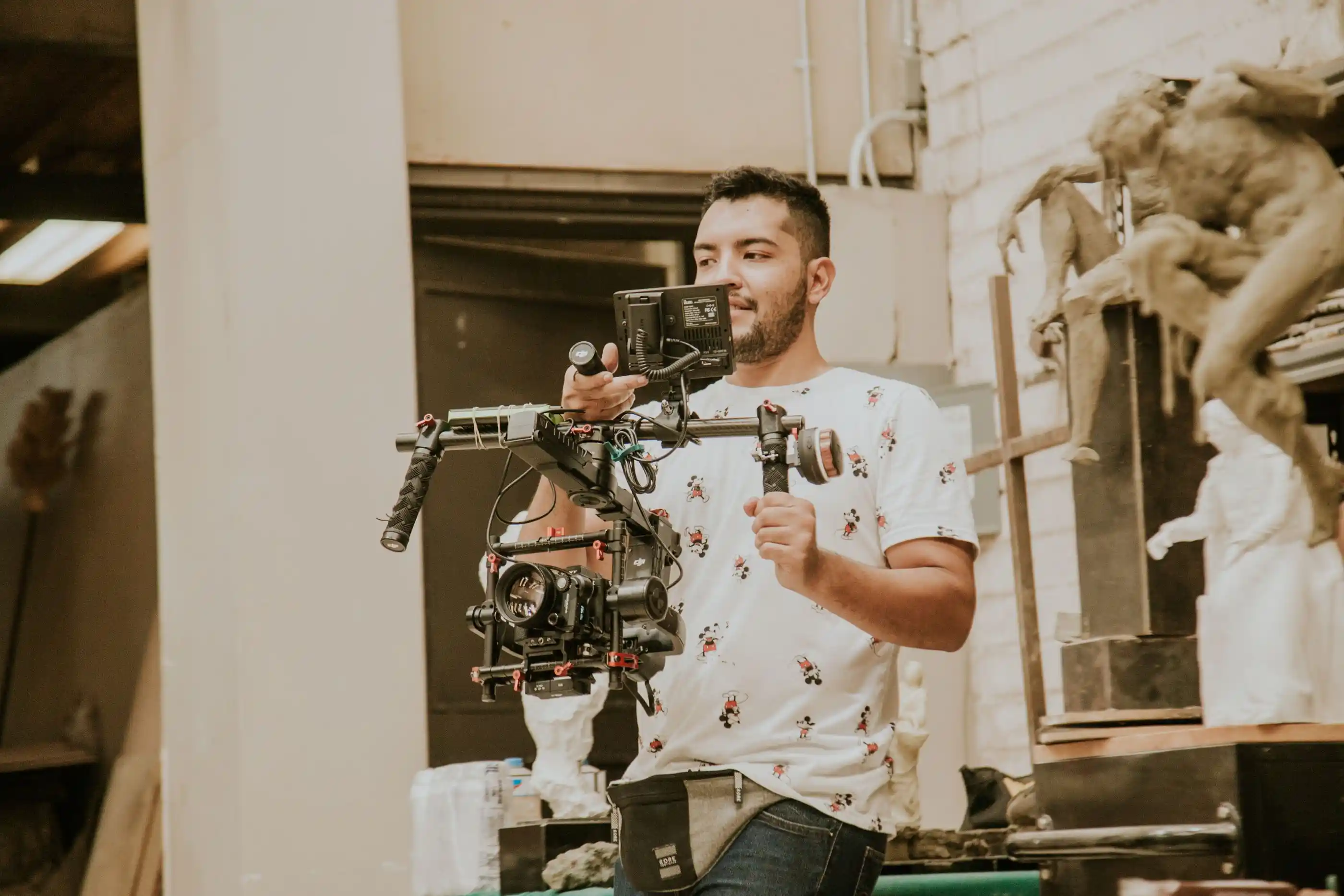 A videographer working with a stabilised camera rig indoors