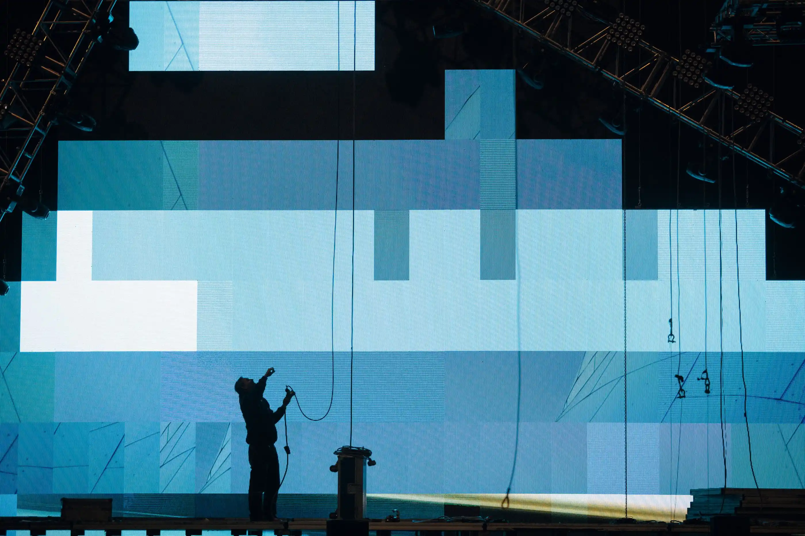 A crew member silhouetted against a screen wall during build