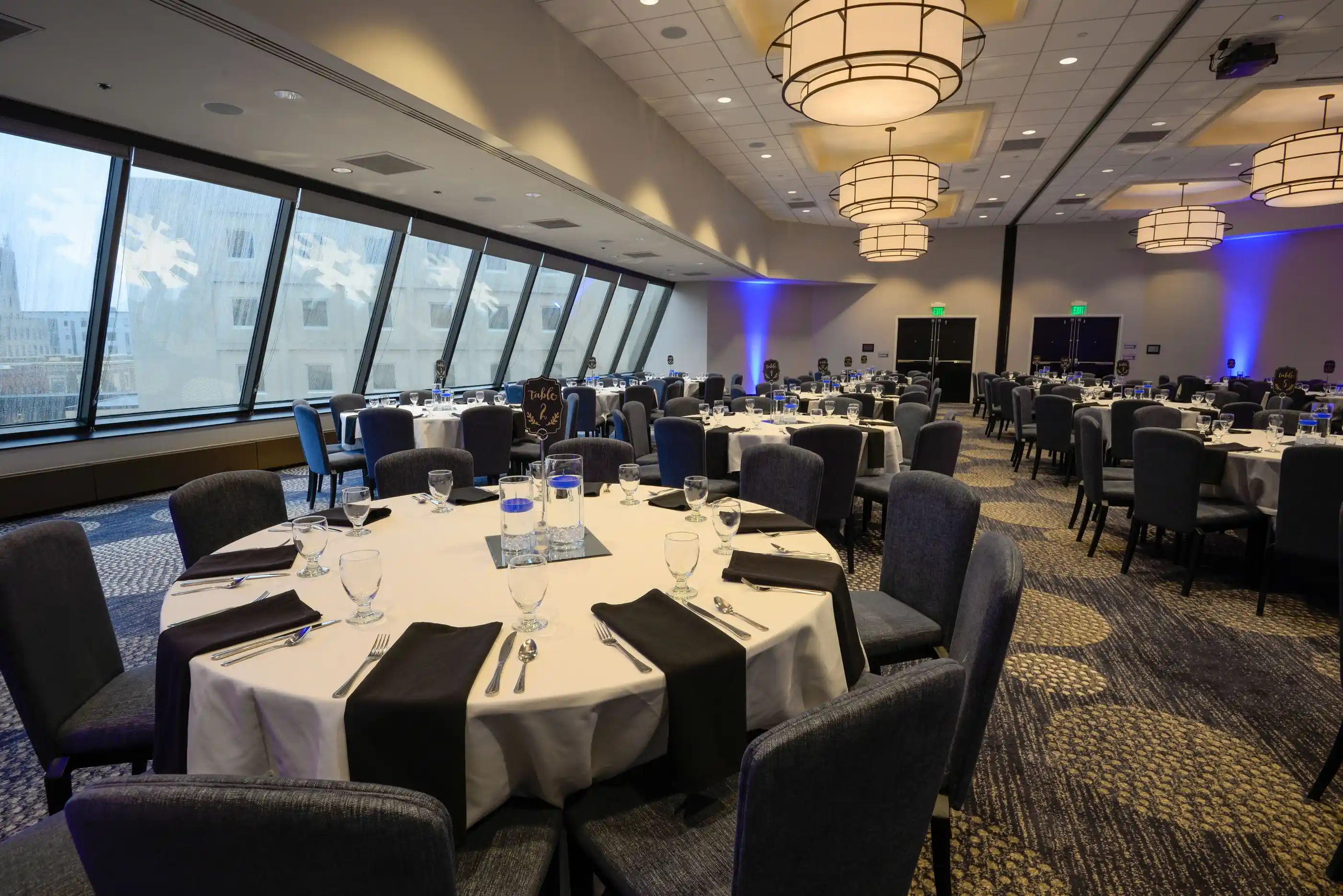 A banquet hall laid with round tables ahead of an event
