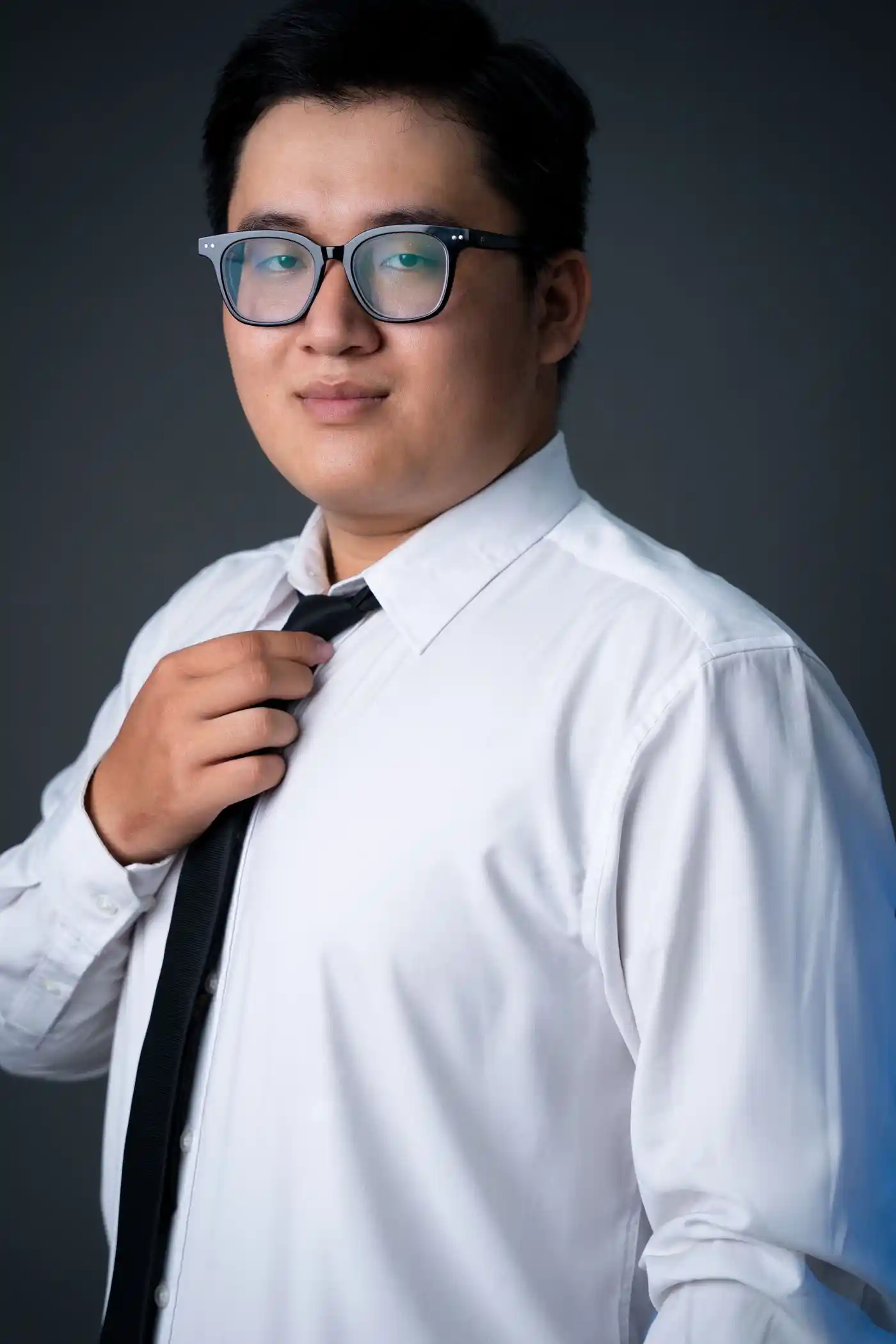 Studio portrait of a man adjusting his tie
