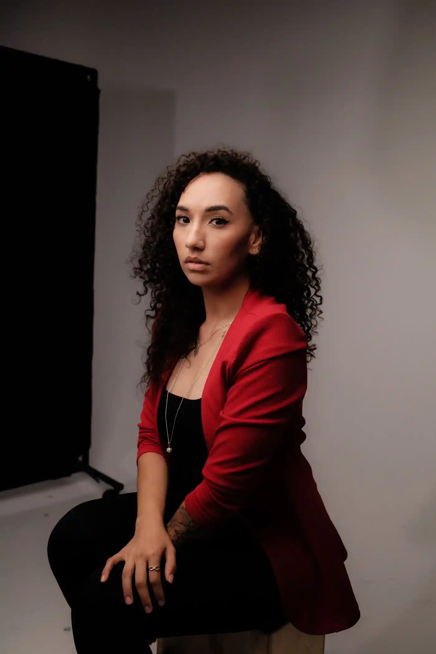Studio portrait of a woman with curly hair in a red jacket