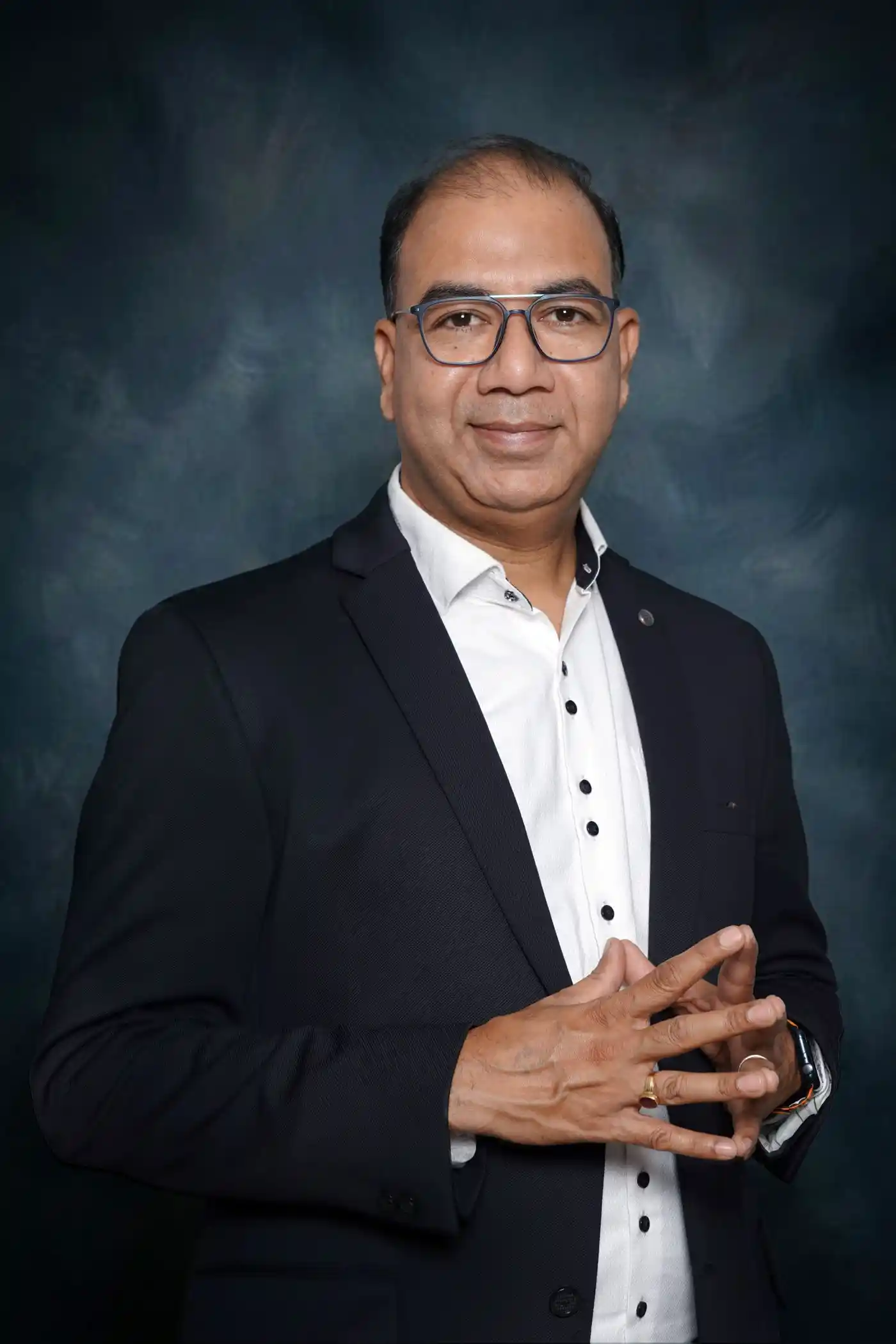 Studio portrait of a man in a dark suit against a plain ground