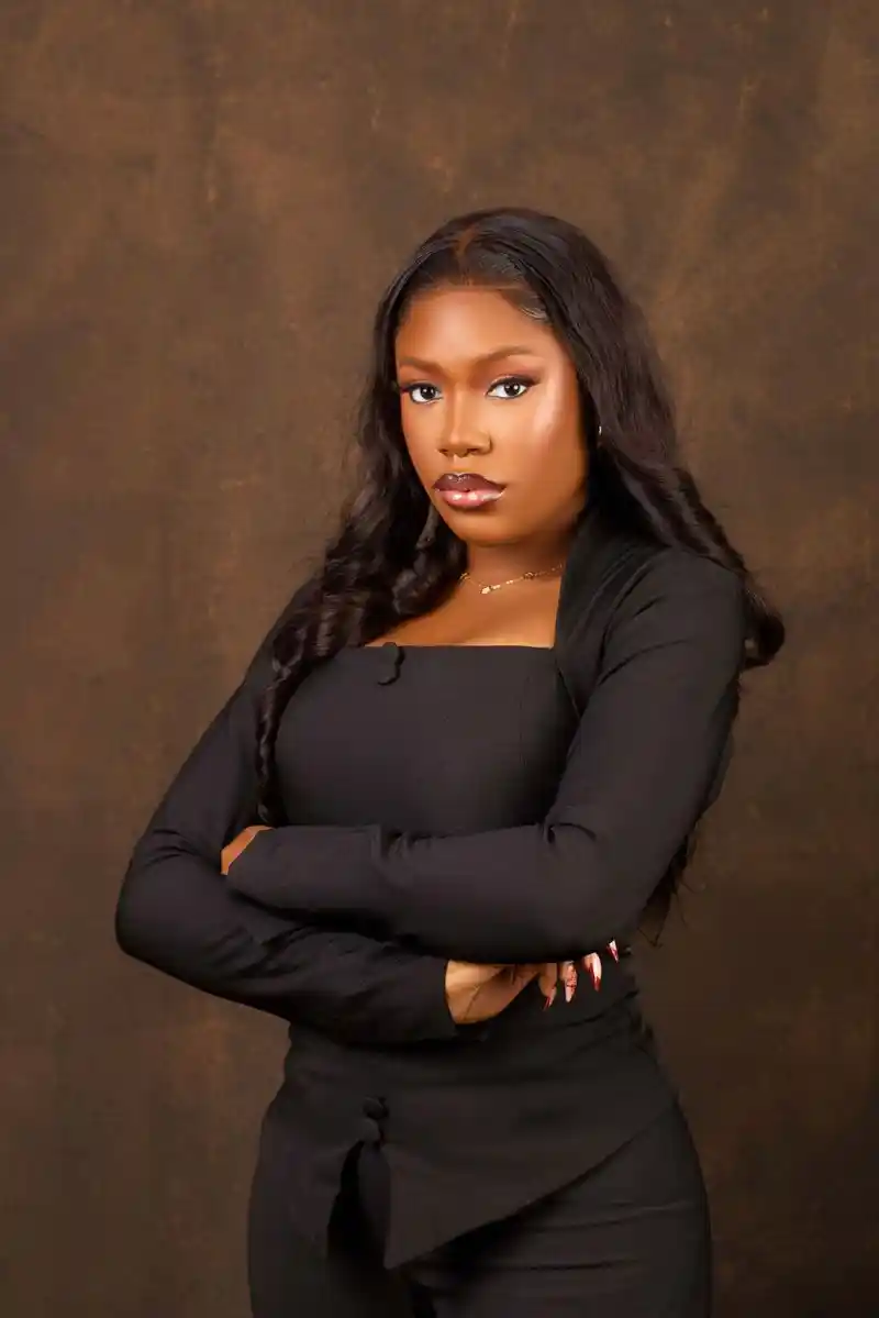 Portrait of a woman in black against a warm backdrop