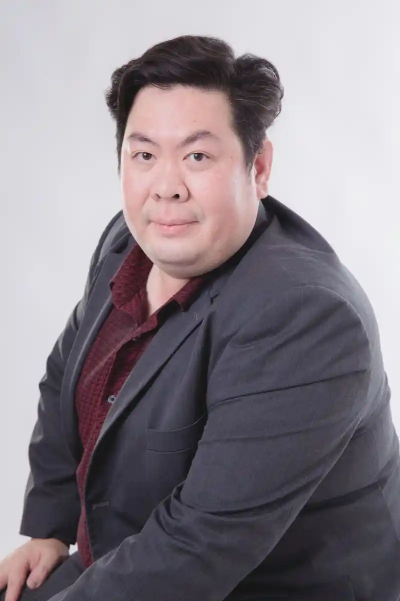 Portrait of a man in a suit against a neutral backdrop