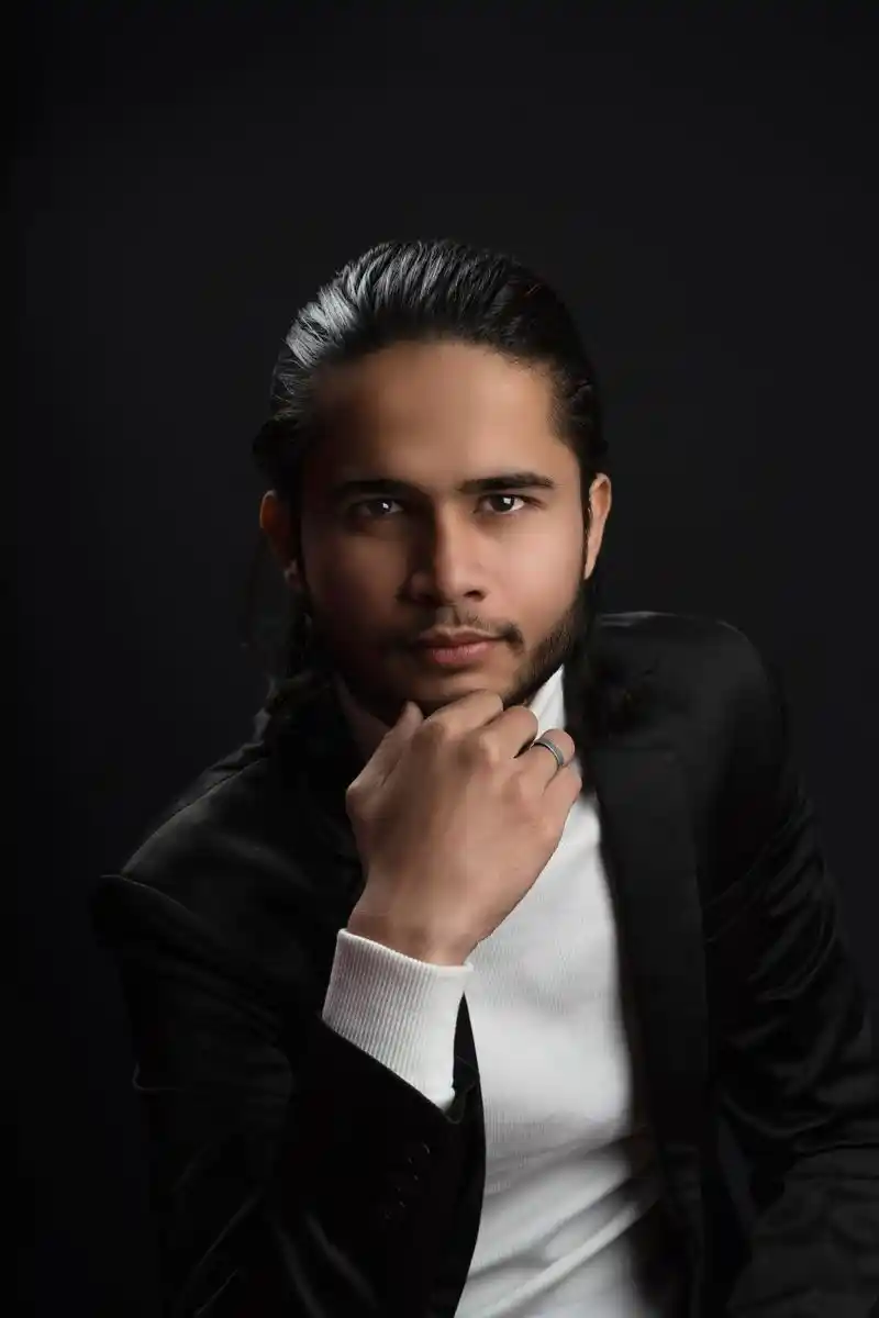 Studio portrait of a young man in a black suit