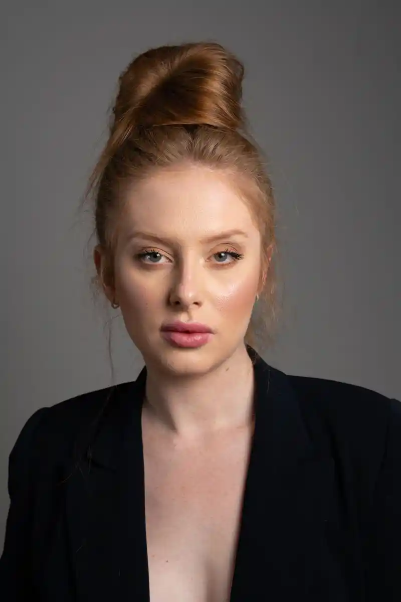 Portrait of a young woman against a grey ground