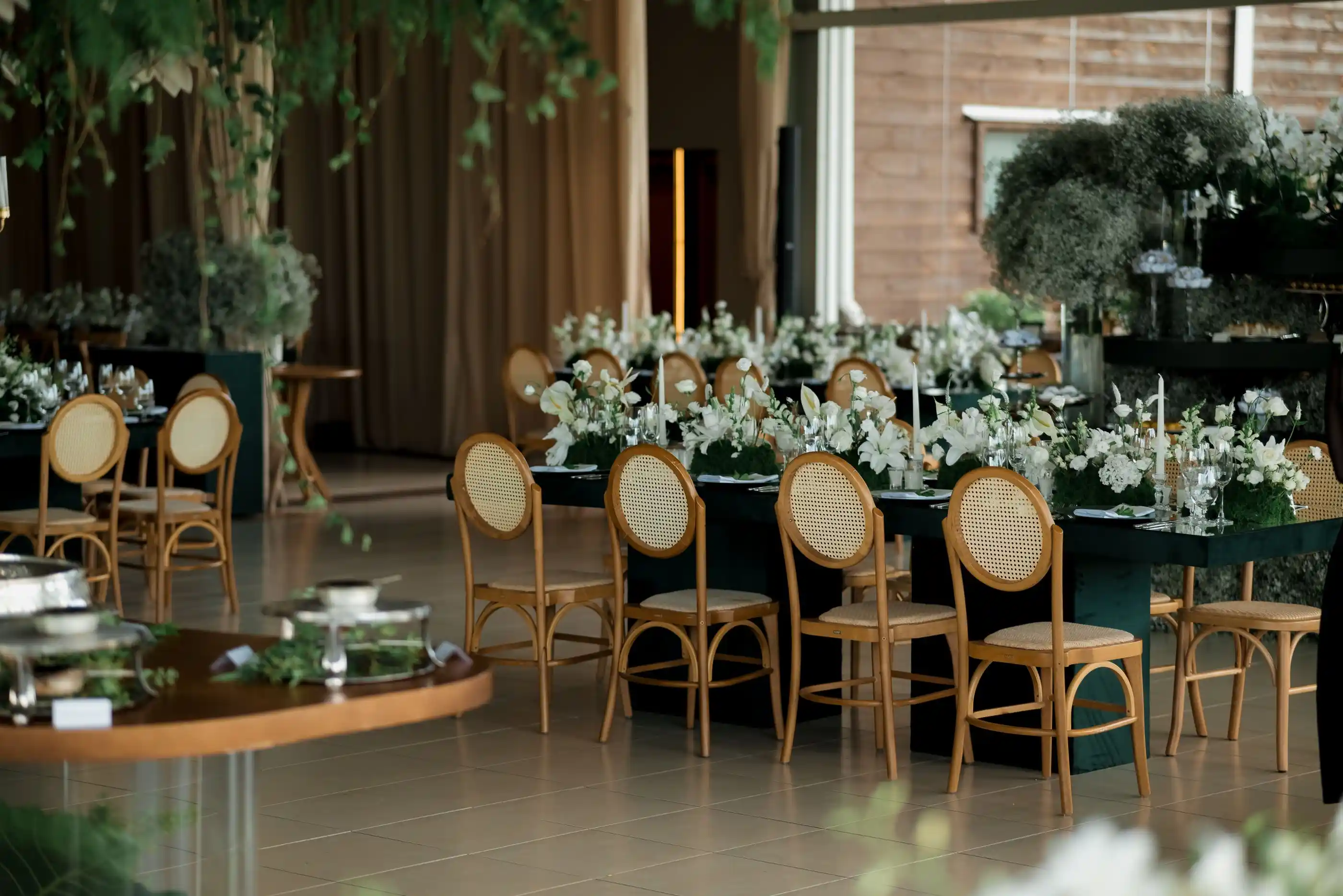 A reception floor with floral arrangements and warm pendant lighting