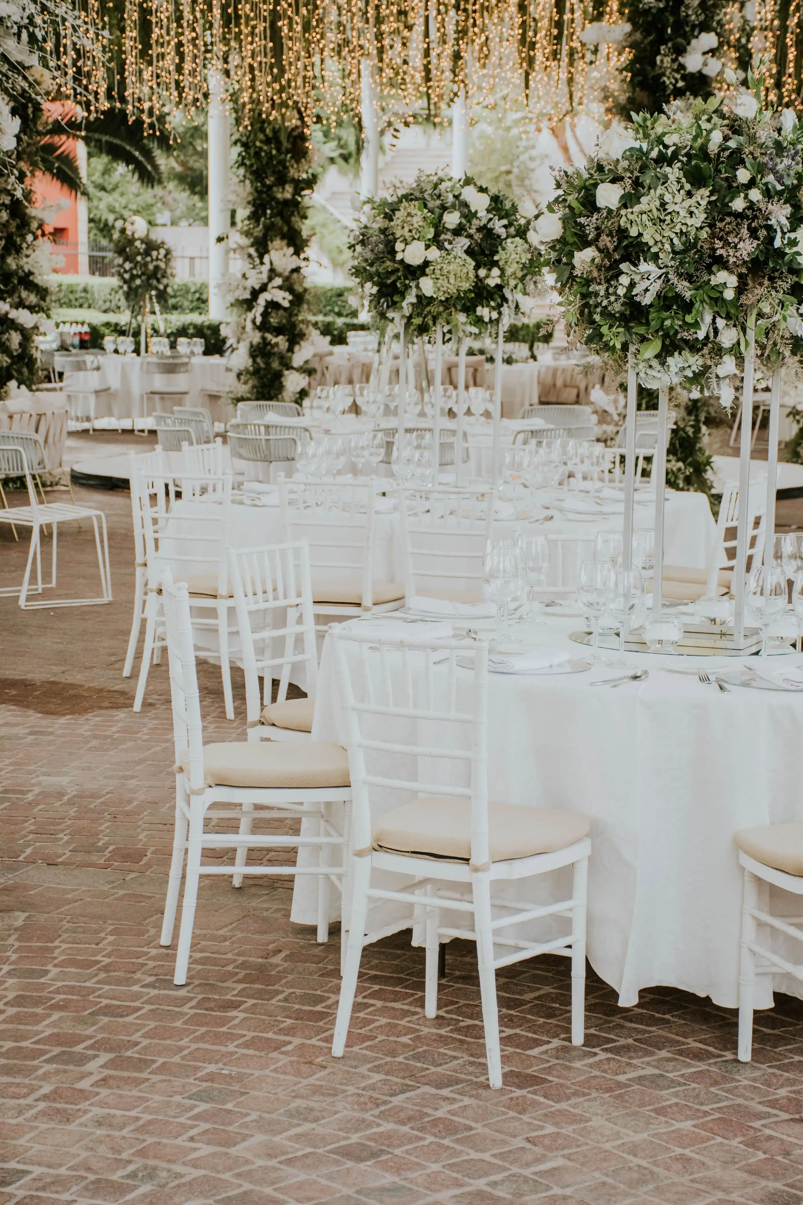 Rows of white chairs and dressed tables in a bright open room