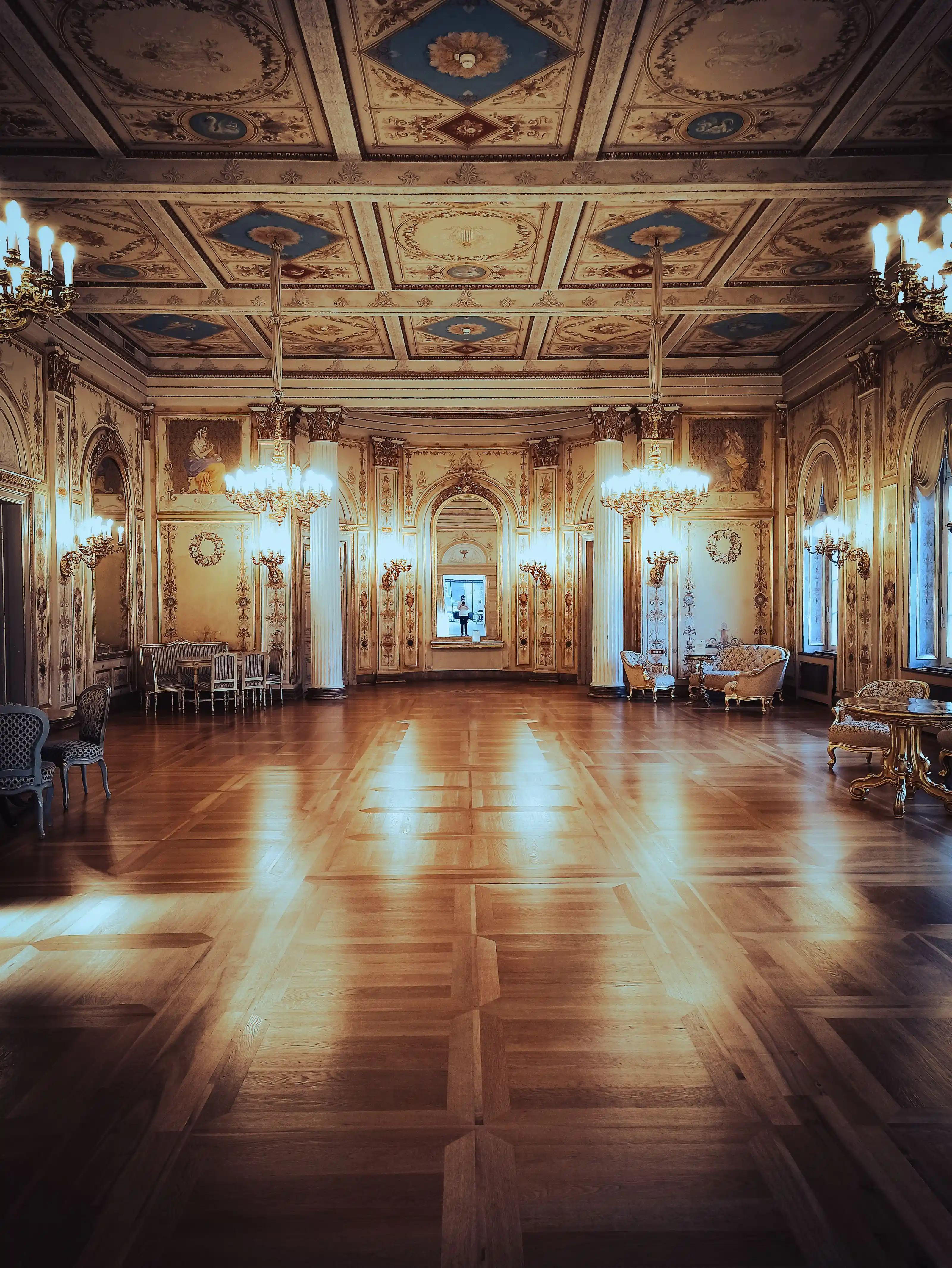 A period ballroom with chandeliers and painted ceiling frescoes