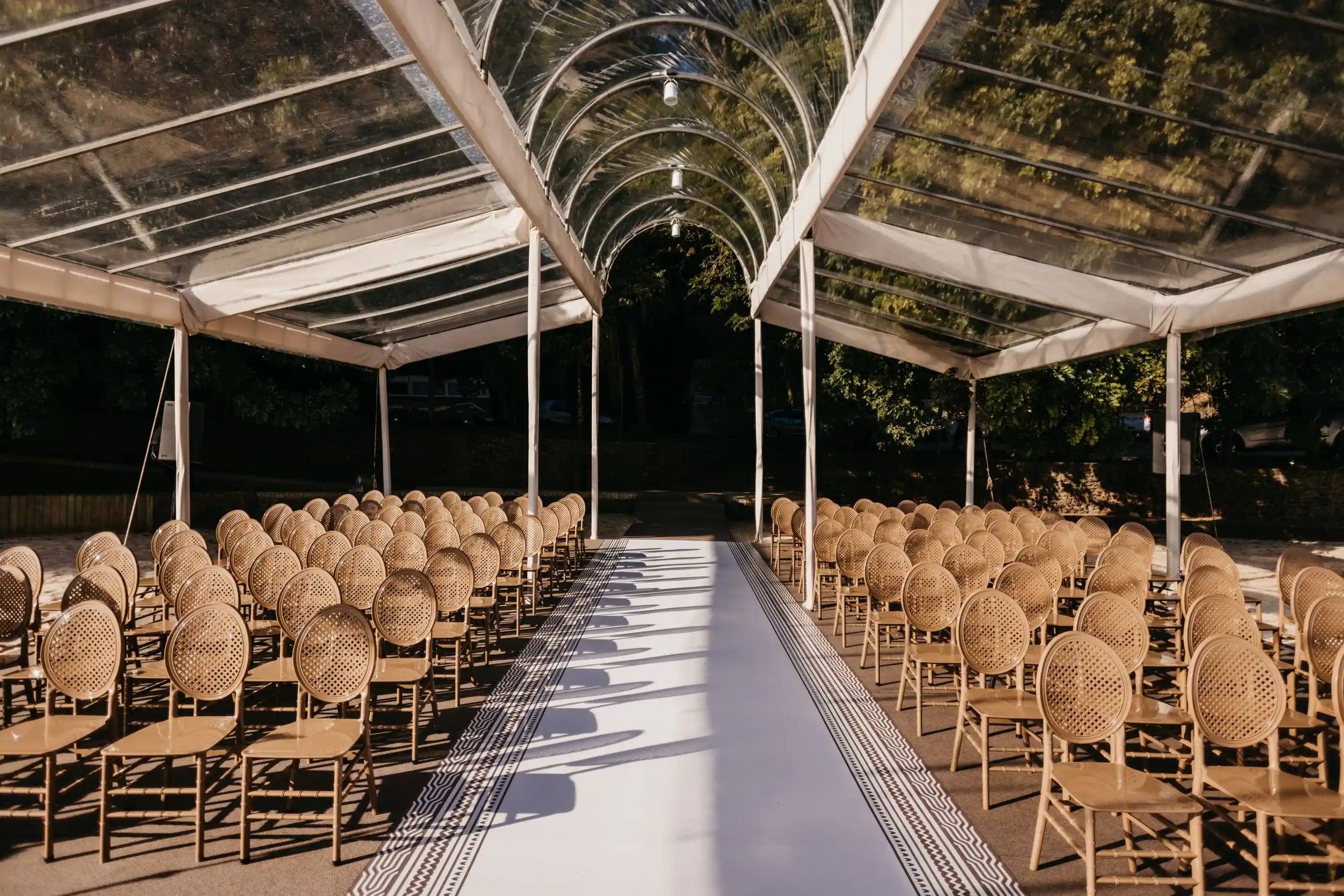Seating set on lawn under a clear marquee