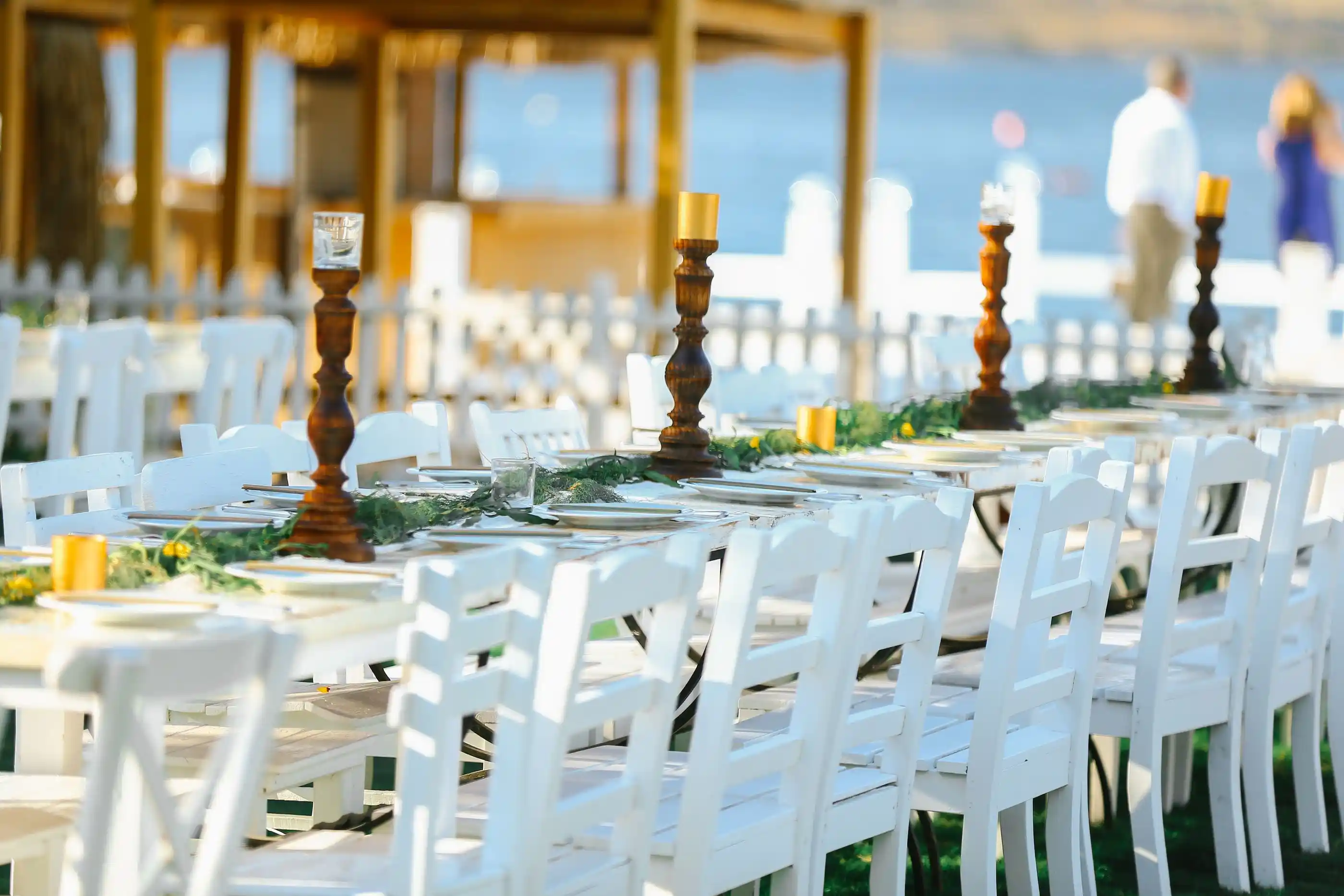 White chairs and dressed tables on grass for an outdoor reception