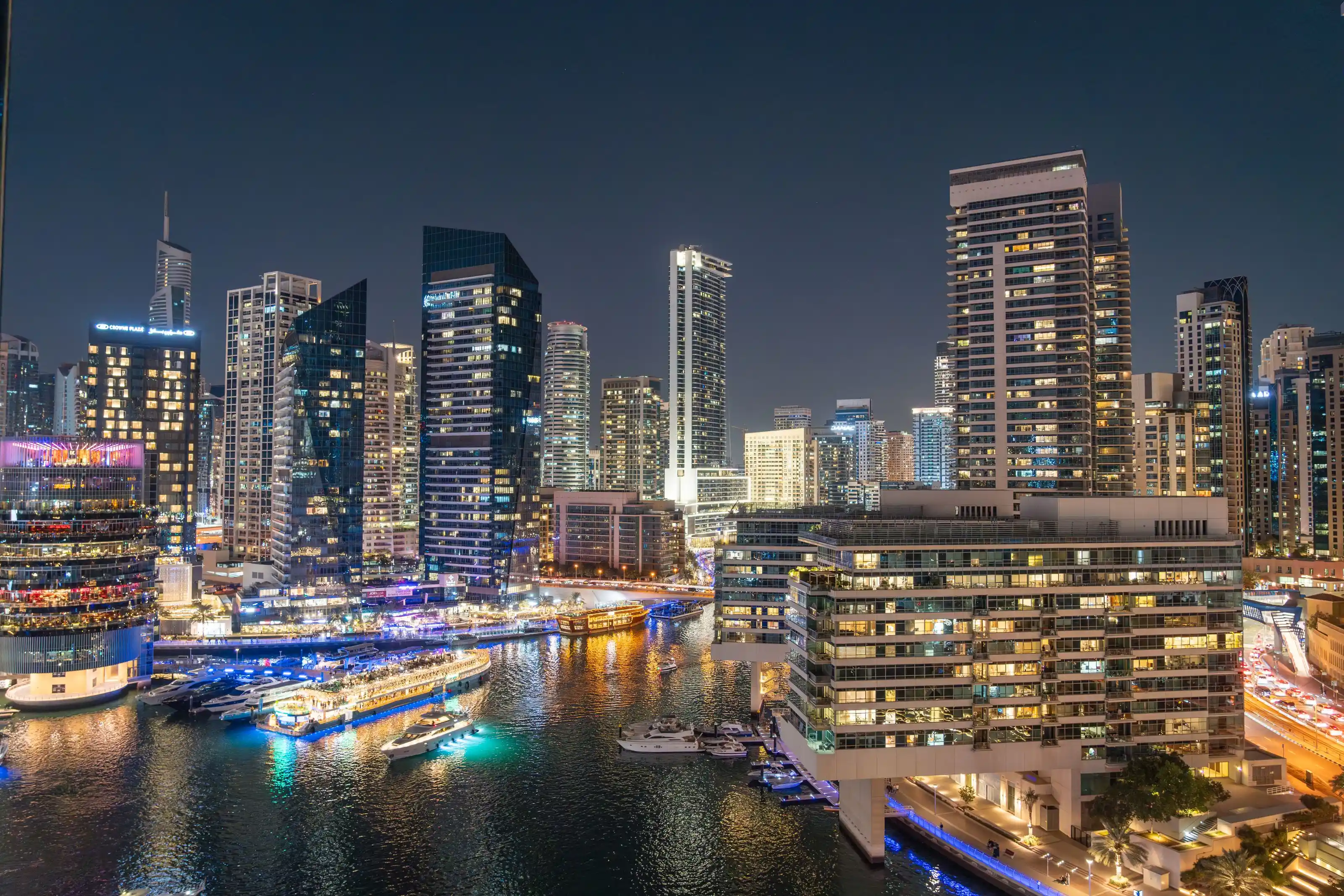 A waterfront city skyline lit up after dark