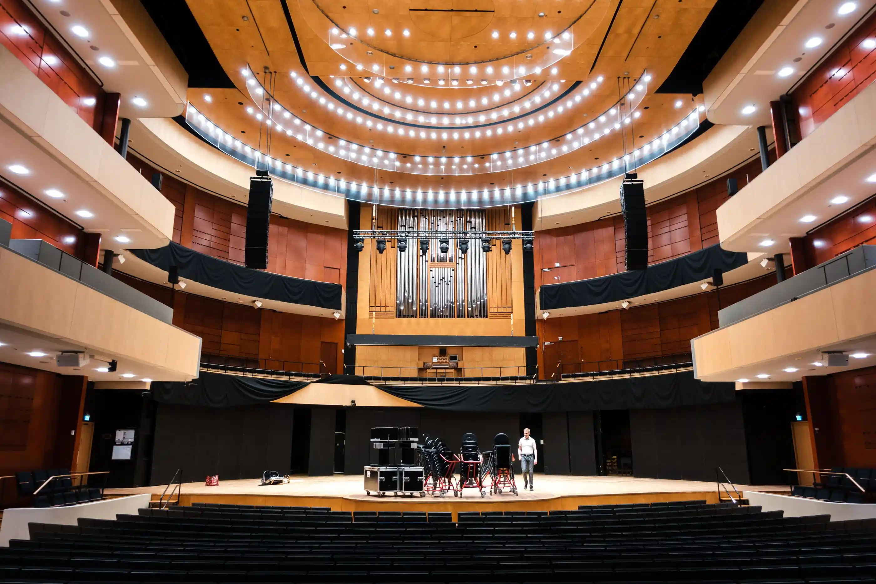 A contemporary auditorium with tiered seating and a wide stage