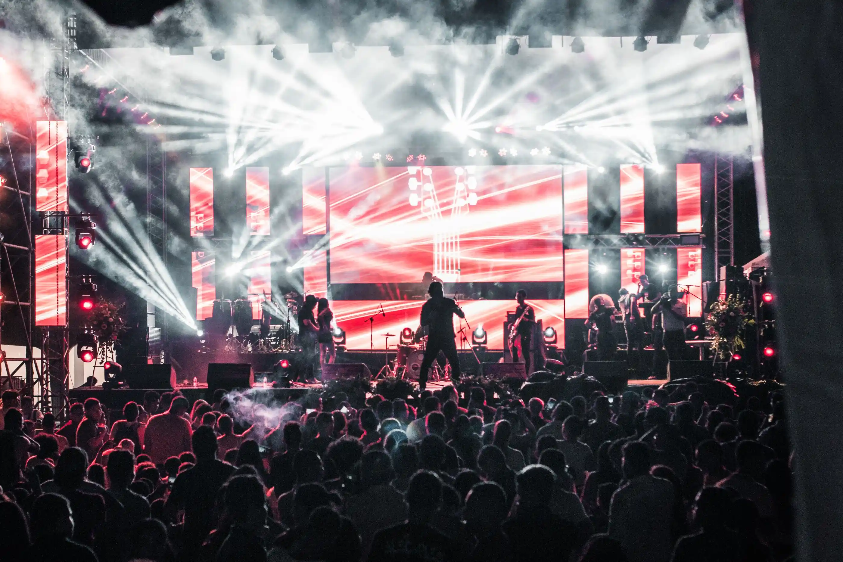 A band performing on a lit stage to a full room
