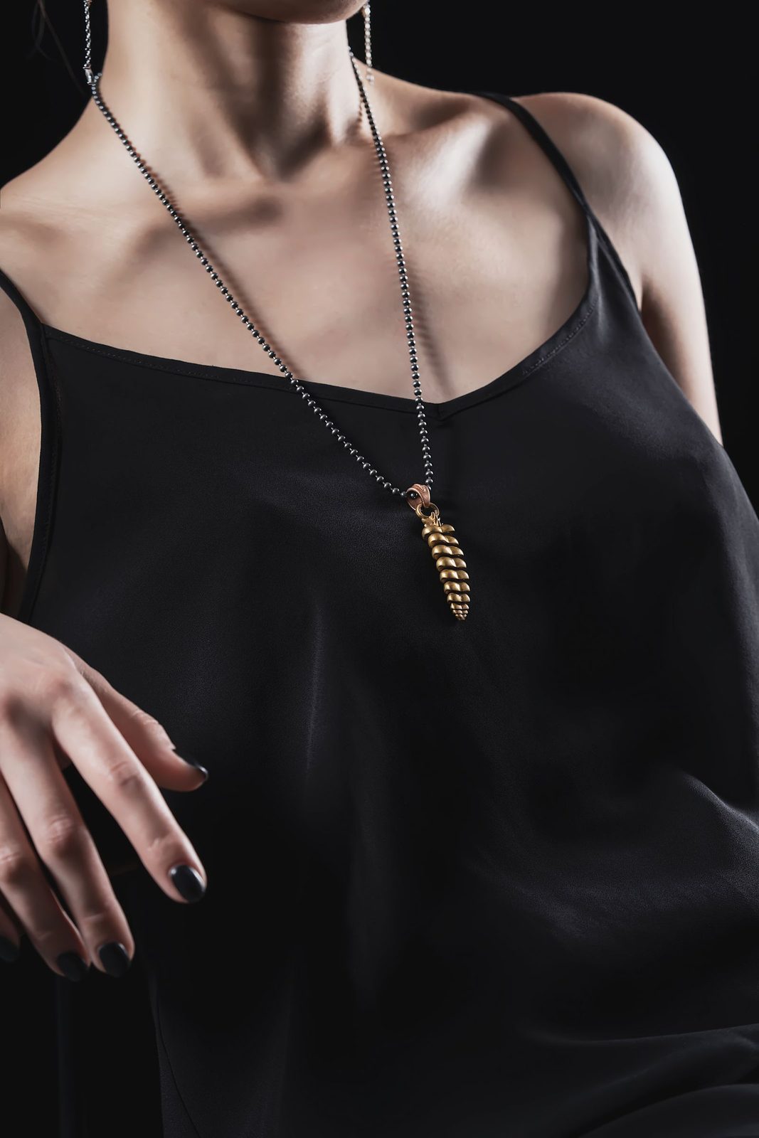 Fine gold pendant necklace worn over a black silk camisole for Alba jewellery
