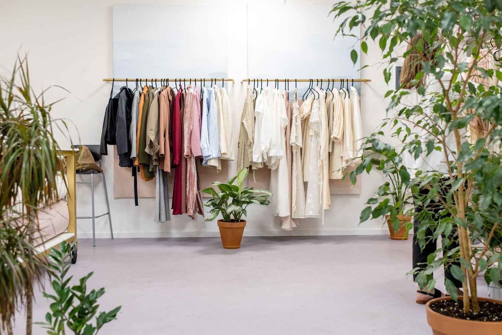 Bright fashion showroom with garment rails and plants for The Common Rail