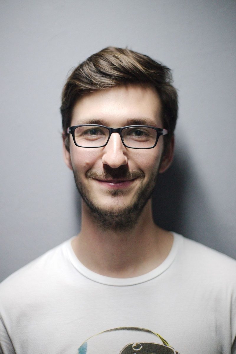 Portrait of Jonas Wray in glasses and a white t-shirt