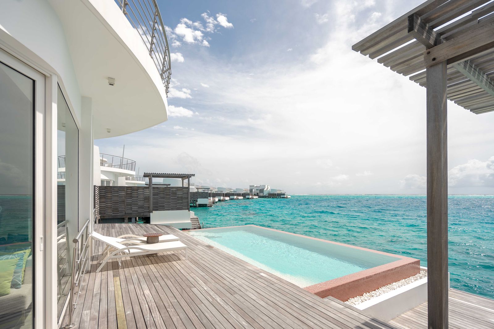 Exterior render of an over-water villa deck with a plunge pool opening to the ocean
