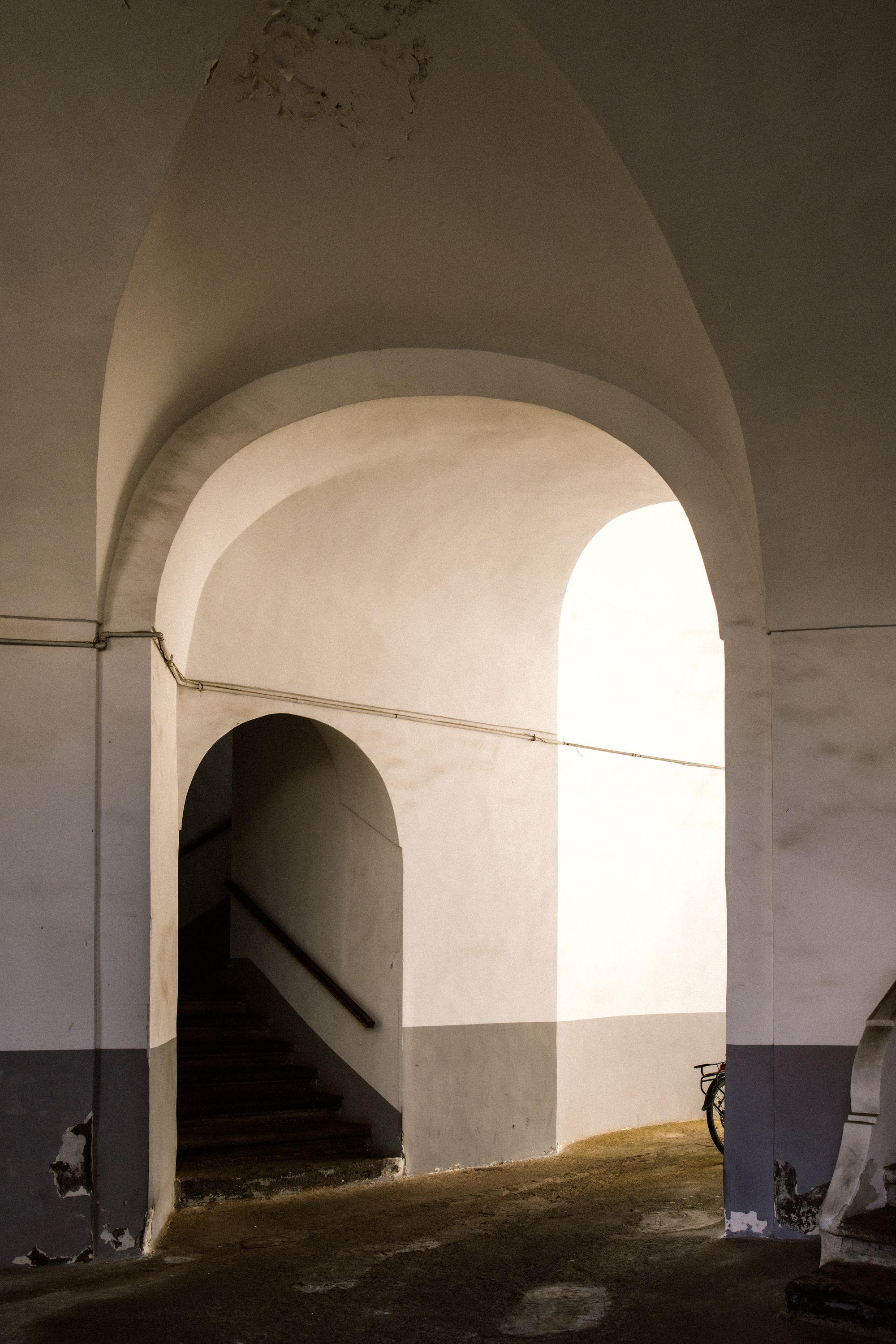 Interior render of a white plaster arched corridor washed in soft Mediterranean daylight
