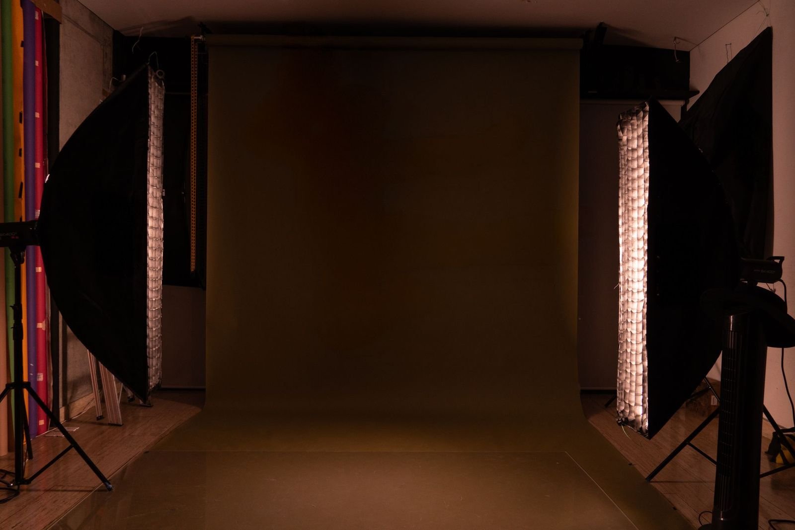 A photography studio lit for a shoot, seamless backdrop rolled to the floor