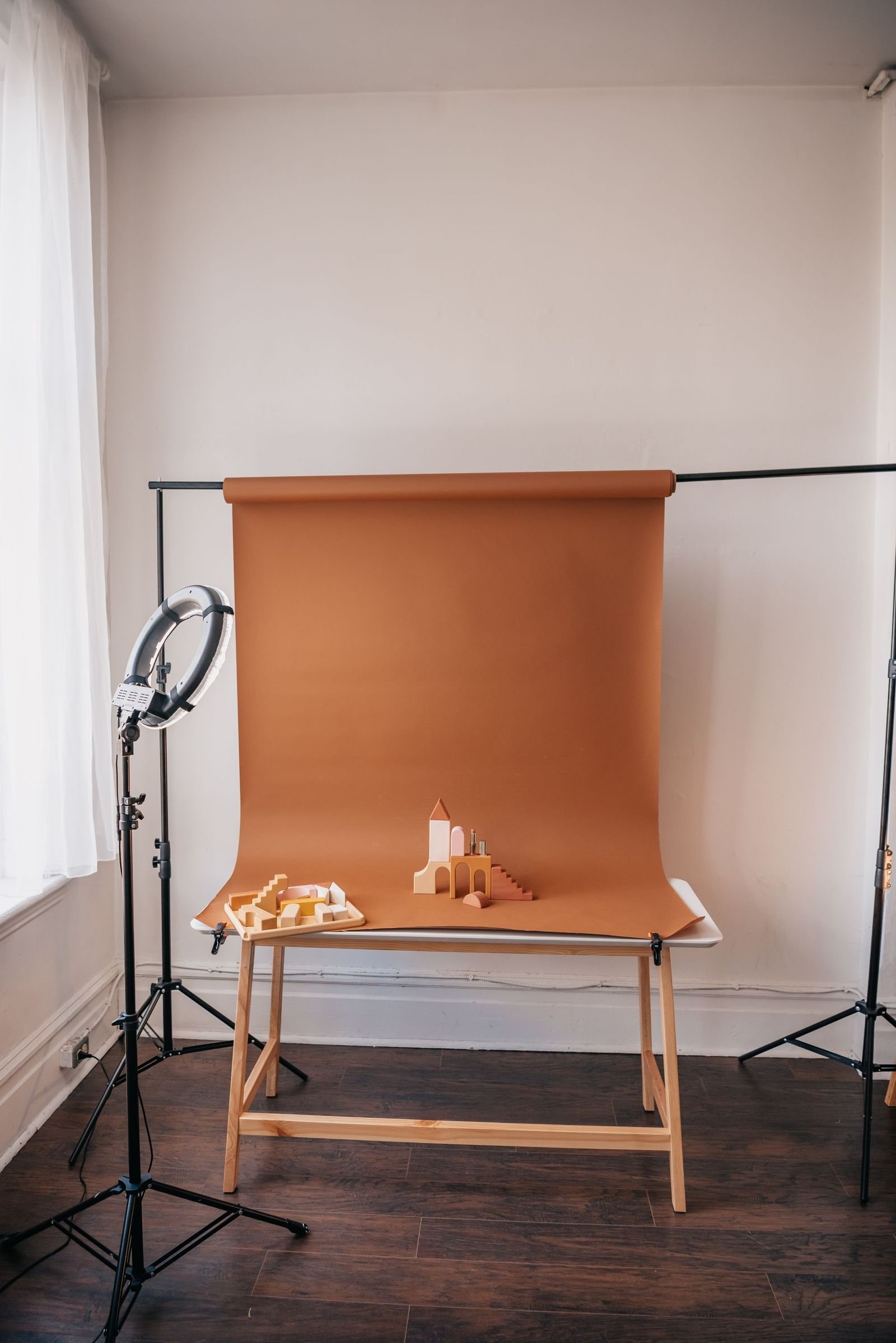 A product shoot in progress: sweep of brown paper, a bare table, one light