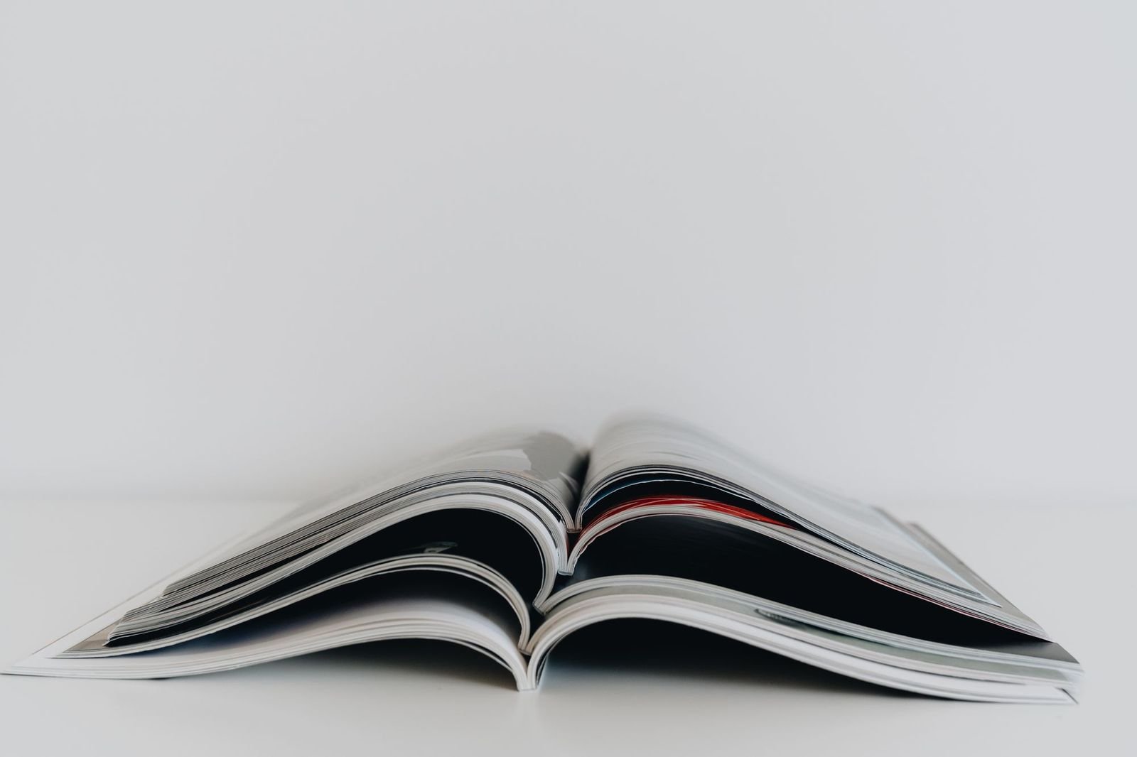 An open magazine on a white table, spread flat at the gutter