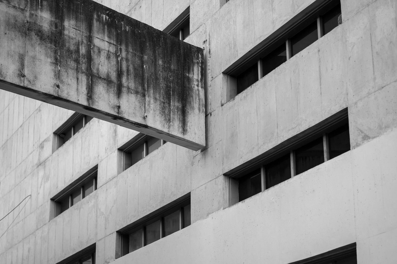 Black and white study of a brutalist apartment block's stacked balconies