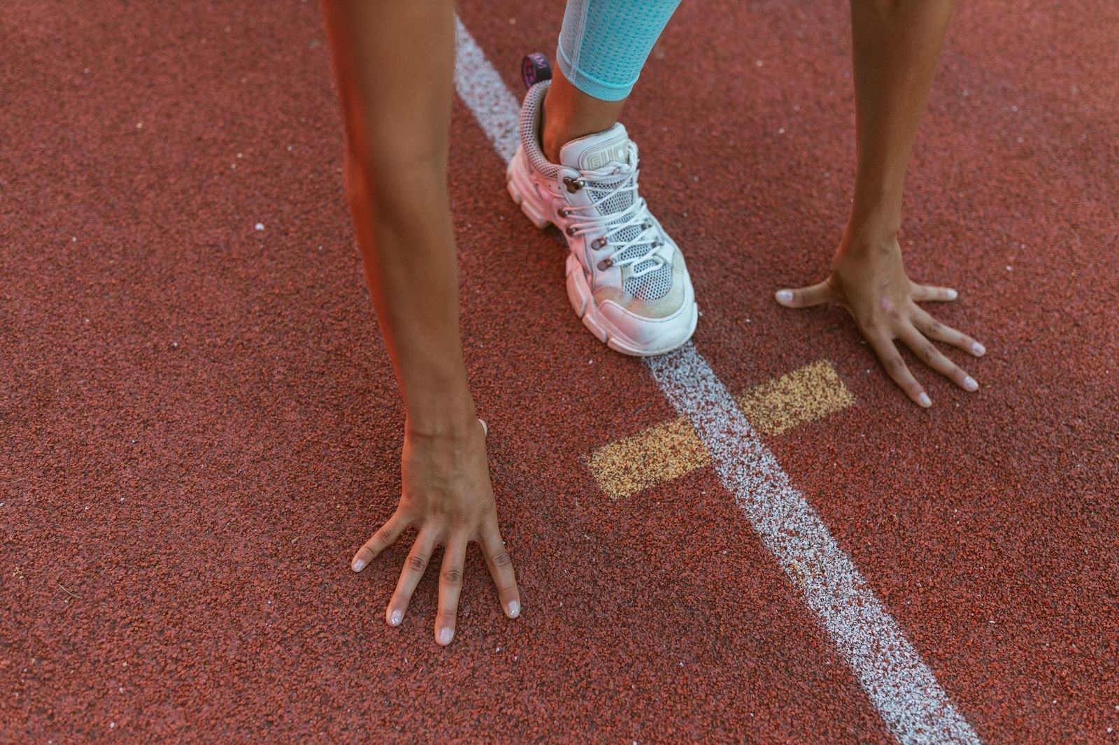 Hands and a front foot braced at the start line, shot low and close