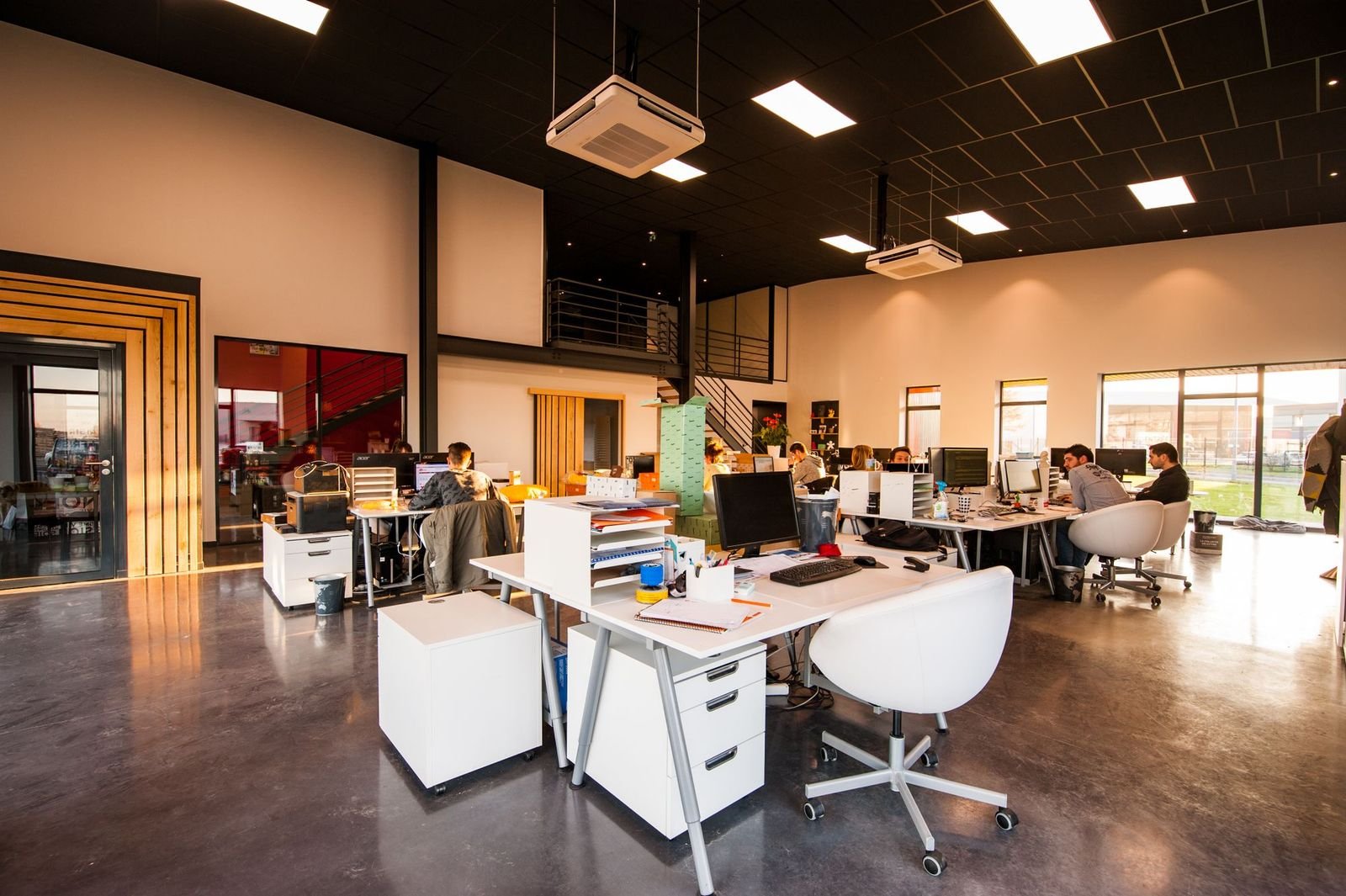 A long open-plan studio floor with daylight down one side