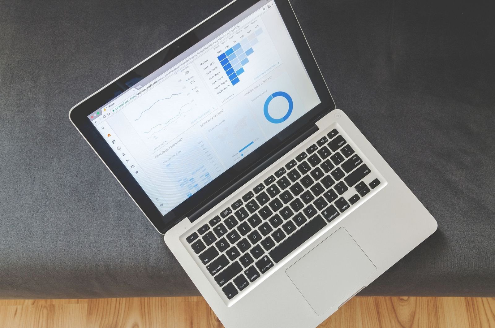 A laptop open on charts and data visualisations, shot from above