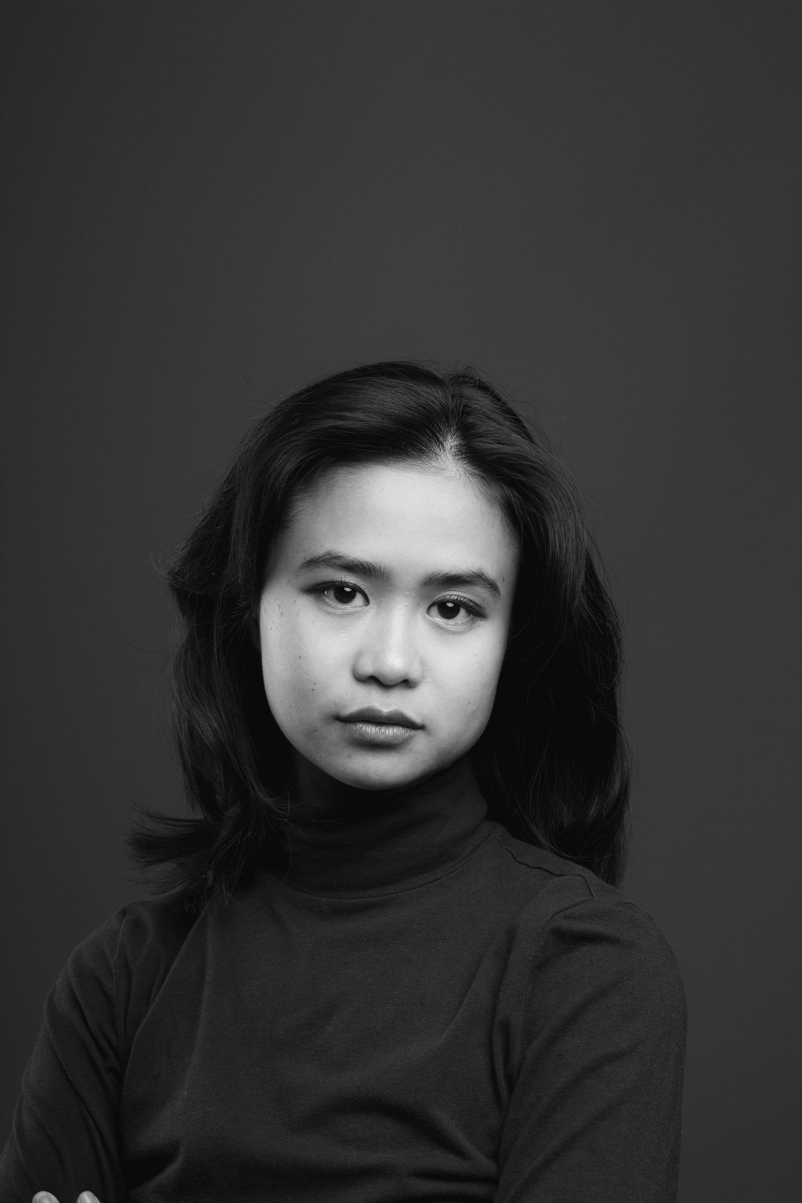 Studio portrait against a dark ground, turned to camera