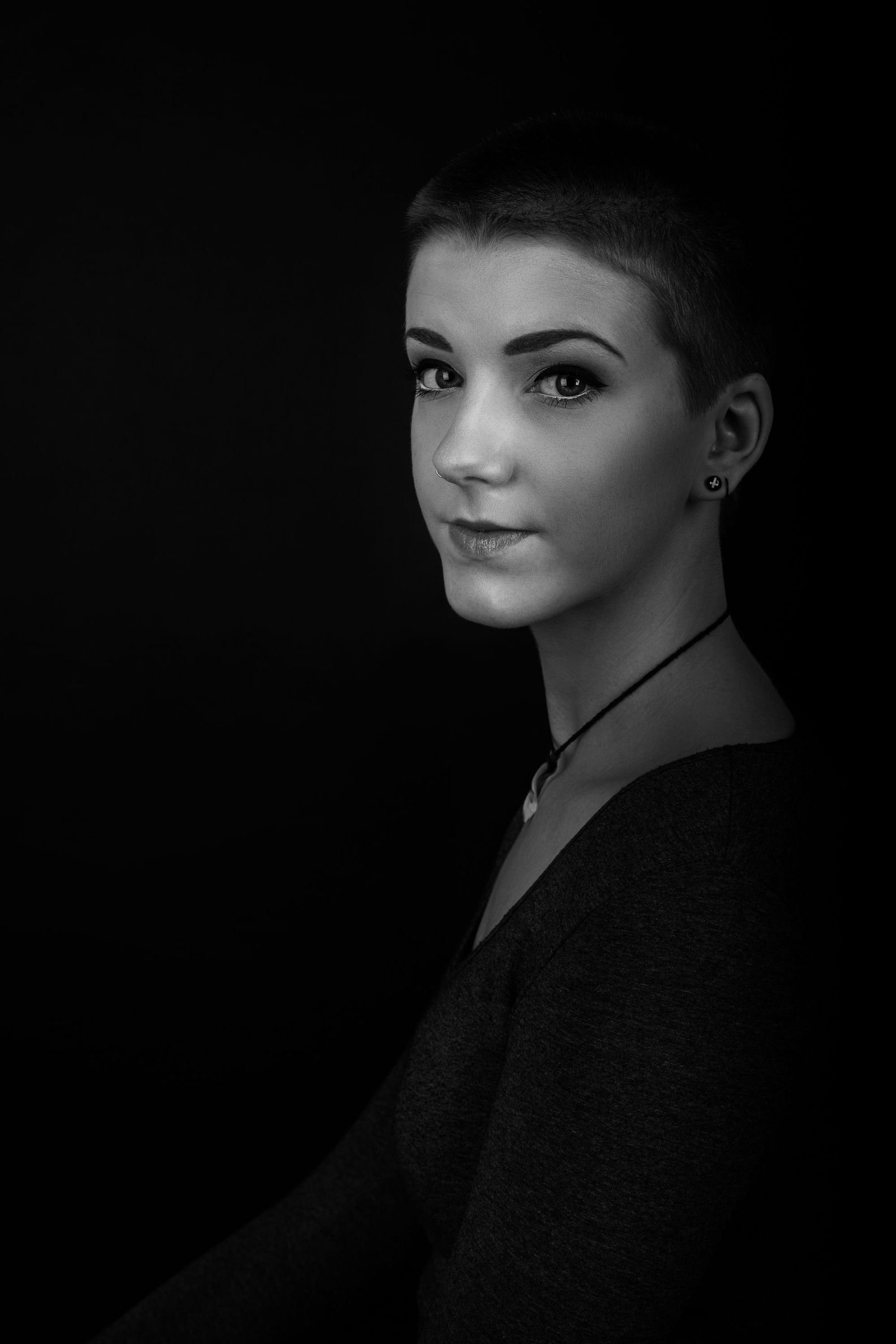 Studio portrait against a dark ground, head and shoulders