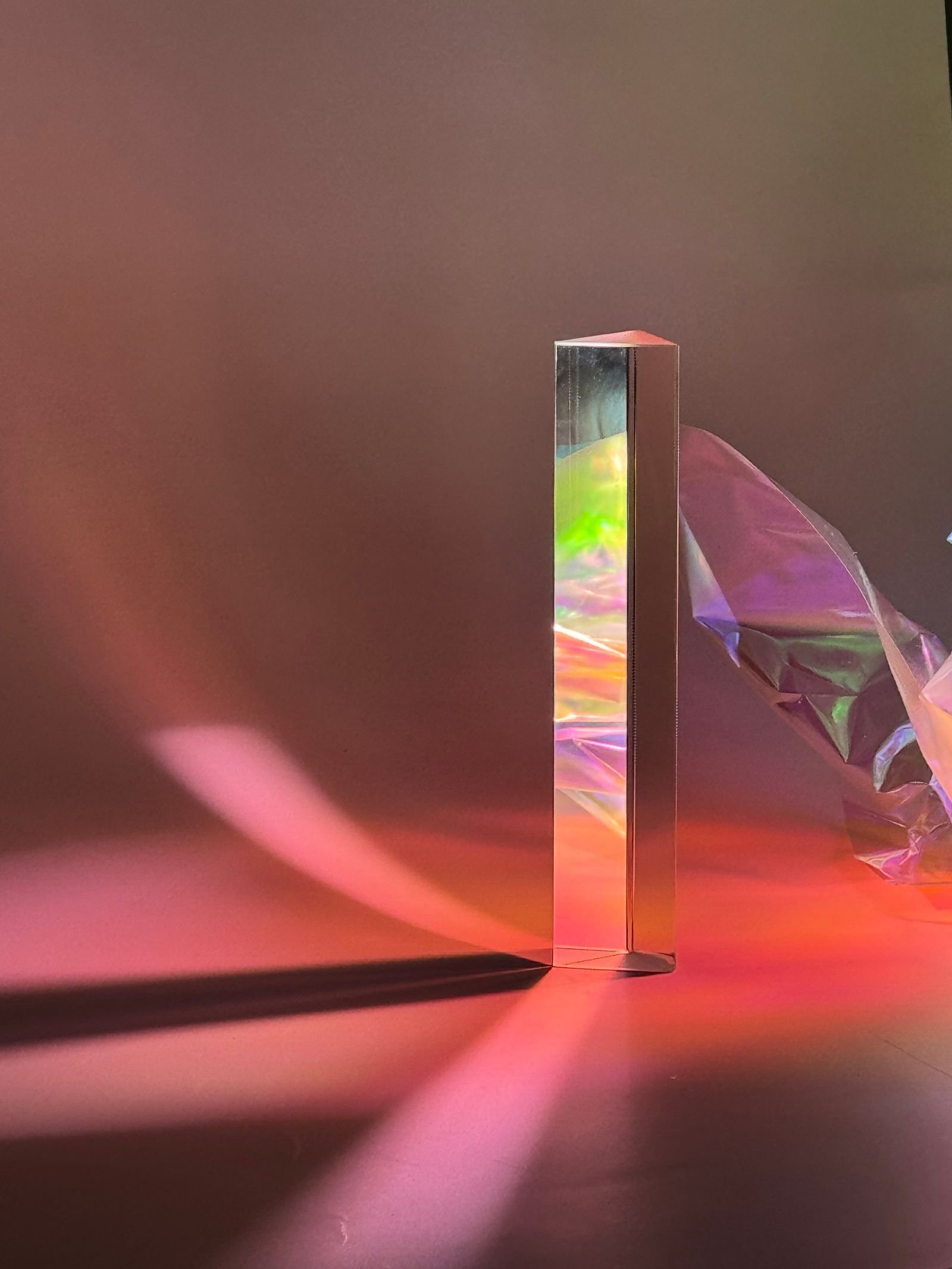 A glass column casting coloured light across a surface