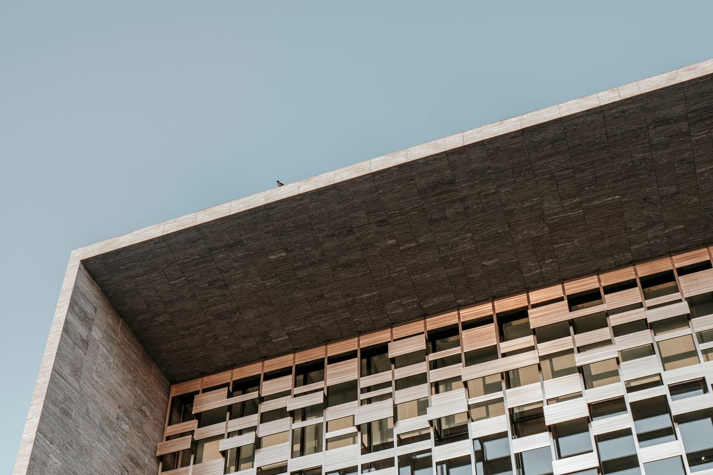 A deep concrete colonnade framing a grid of windows
