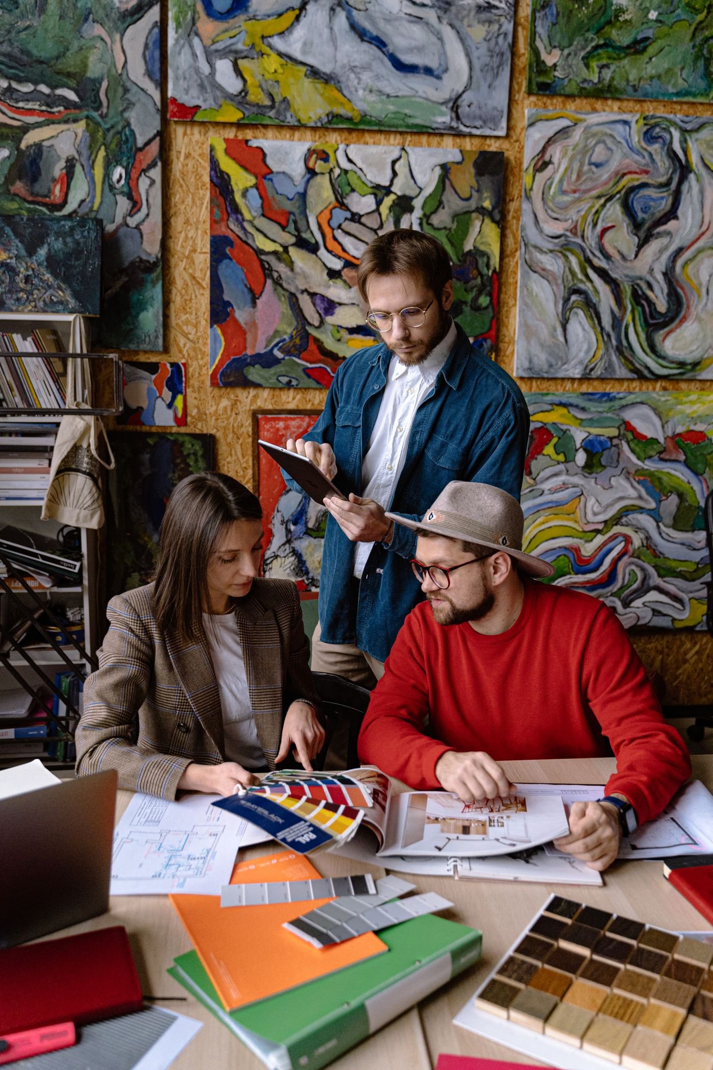 Three designers reviewing artwork together in a bright studio