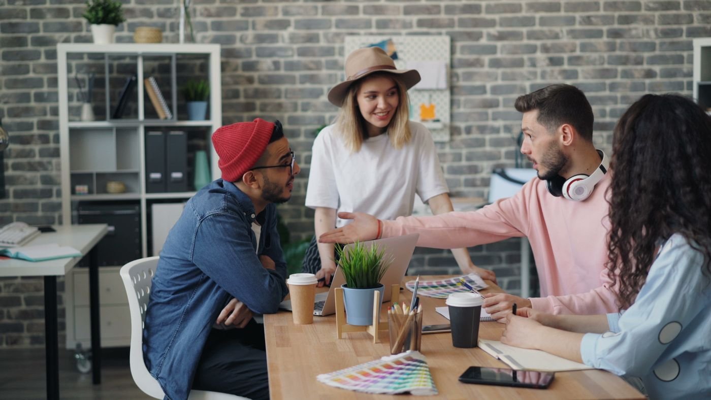 A team meeting around a table with colour swatches and laptops