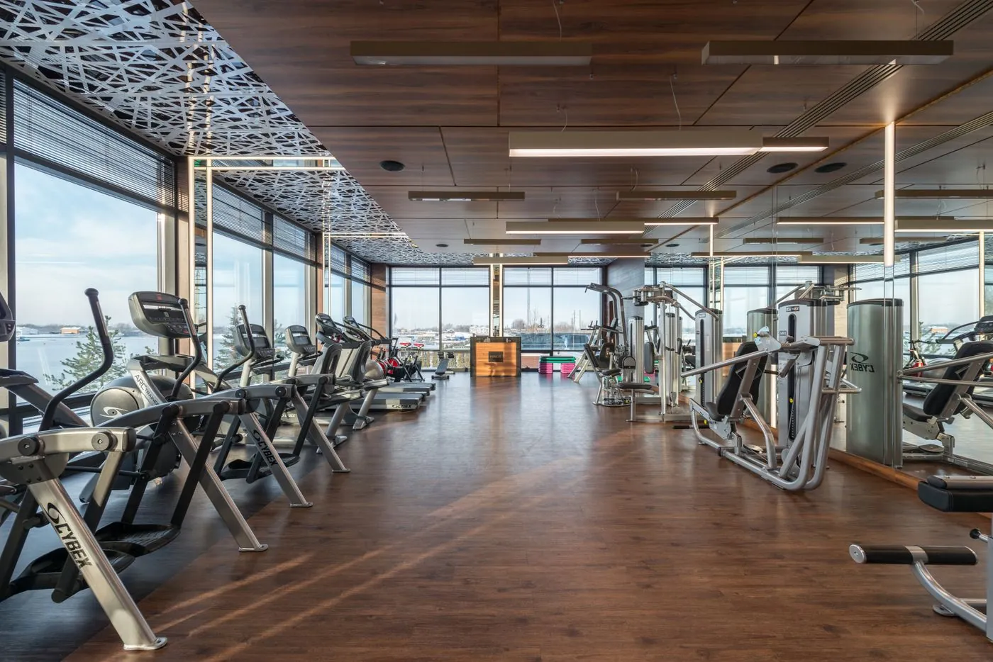 Wide view of a modern club floor with treadmills and glass walls