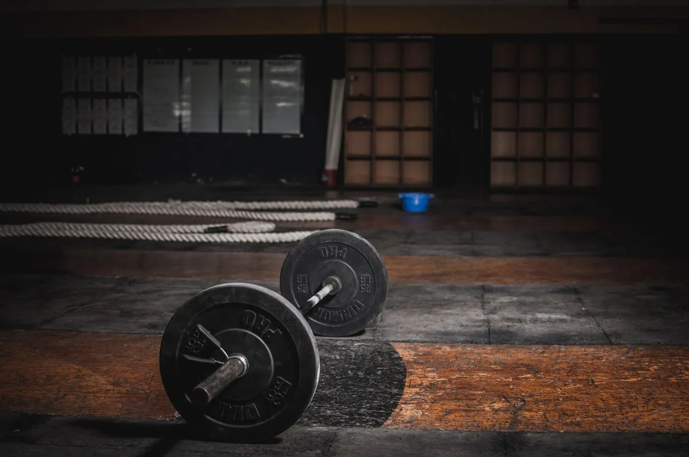 Loaded barbell resting on a dark timber gym floor